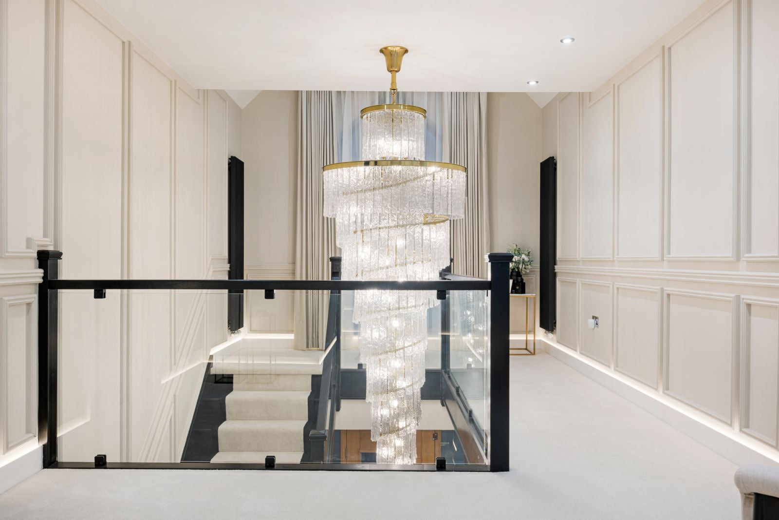 Luxury staircase chandelier in Dubai villa featuring long cascading crystal design for double-height stairwell in UAE