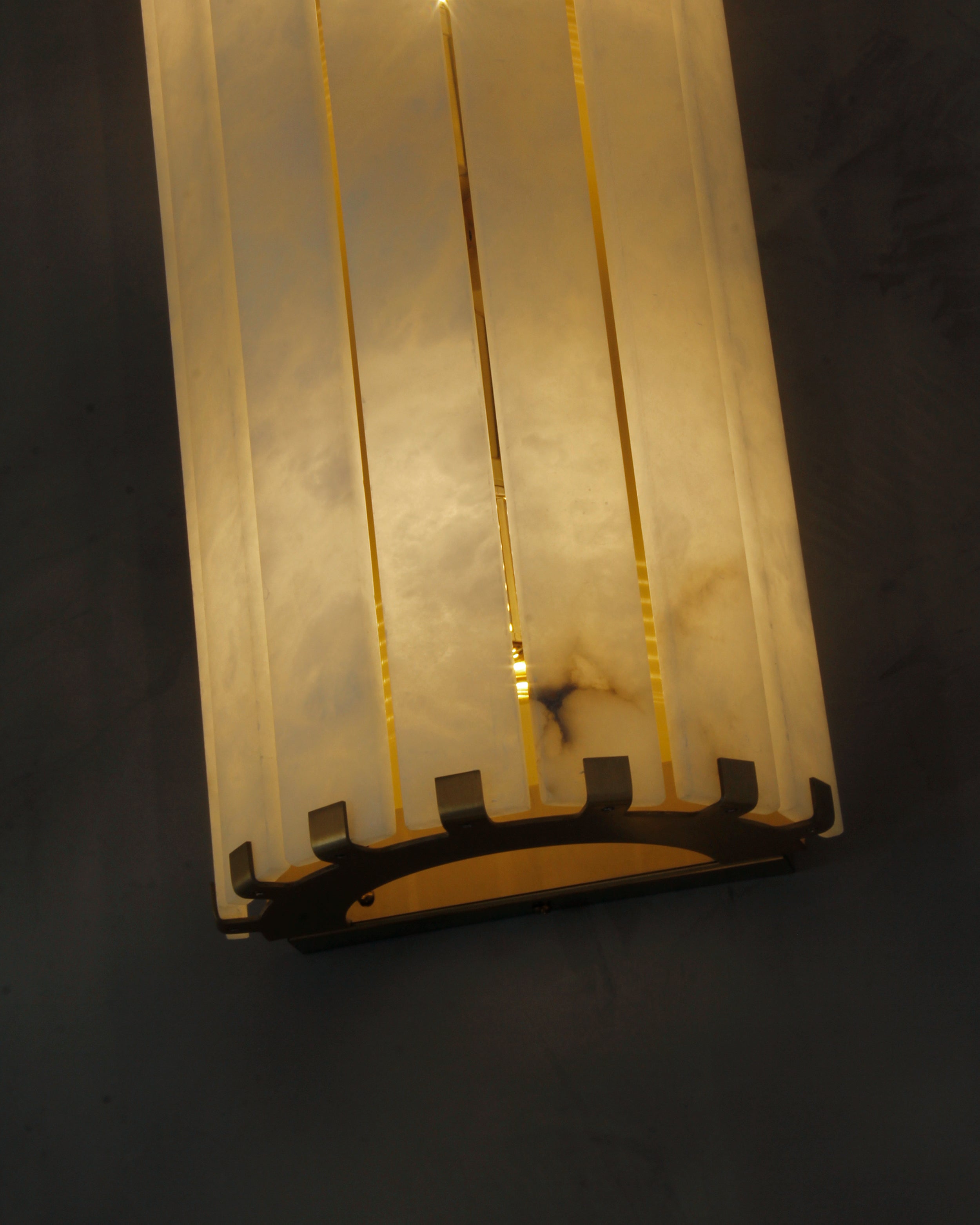 cicci marble wall light angled view highlighting brass accents and tall design