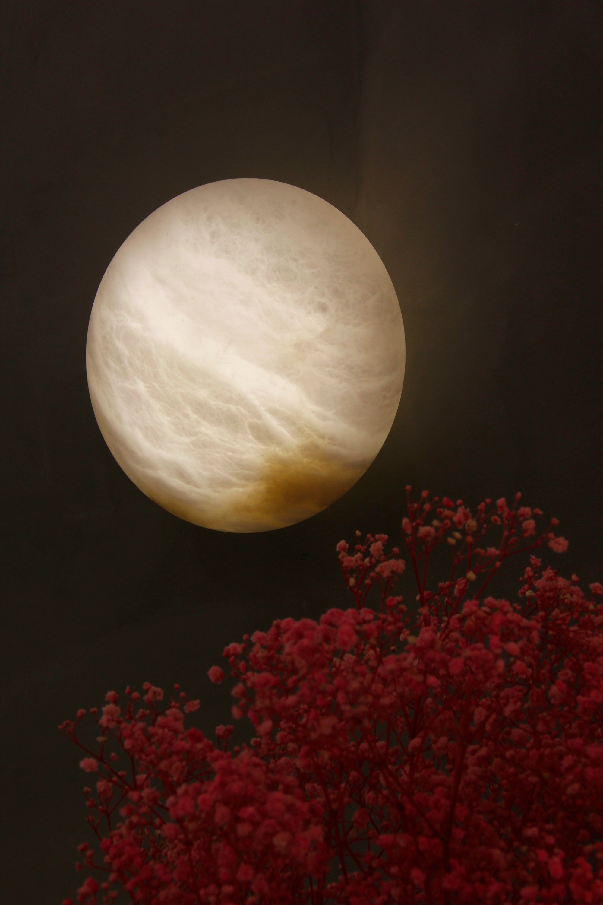close up of como marble wall light showing natural veining and warm illumination