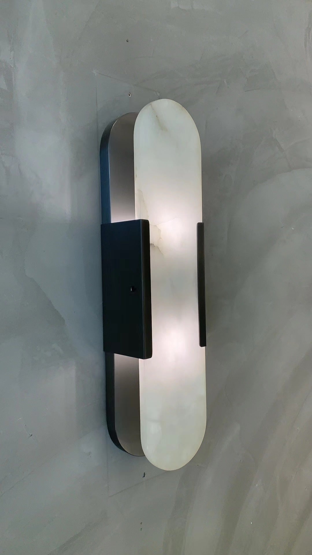 modern marble wall light installed against textured surface with warm illumination