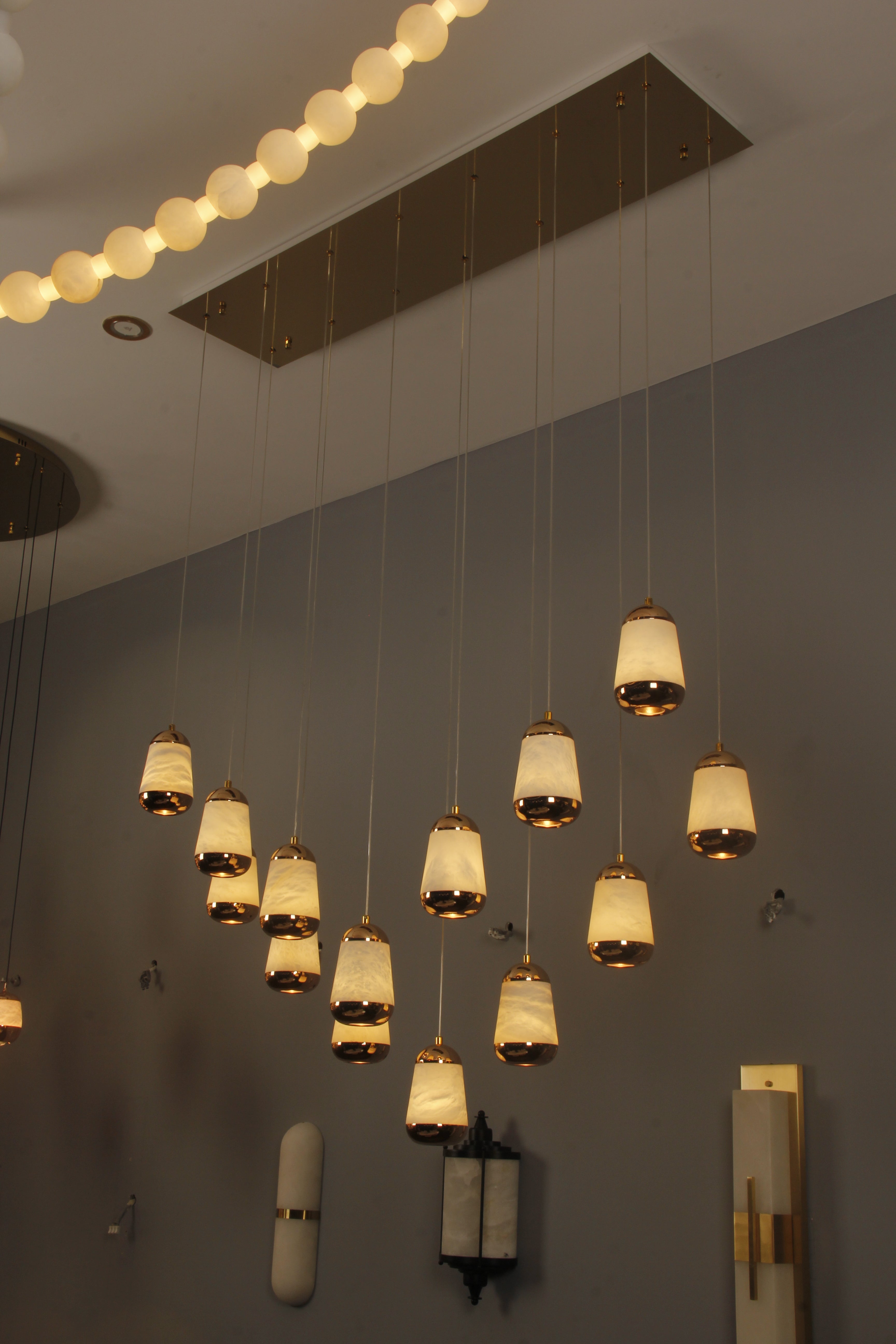 Giovanni marble rectangular chandelier illuminating a grand staircase with cascading pendant drops