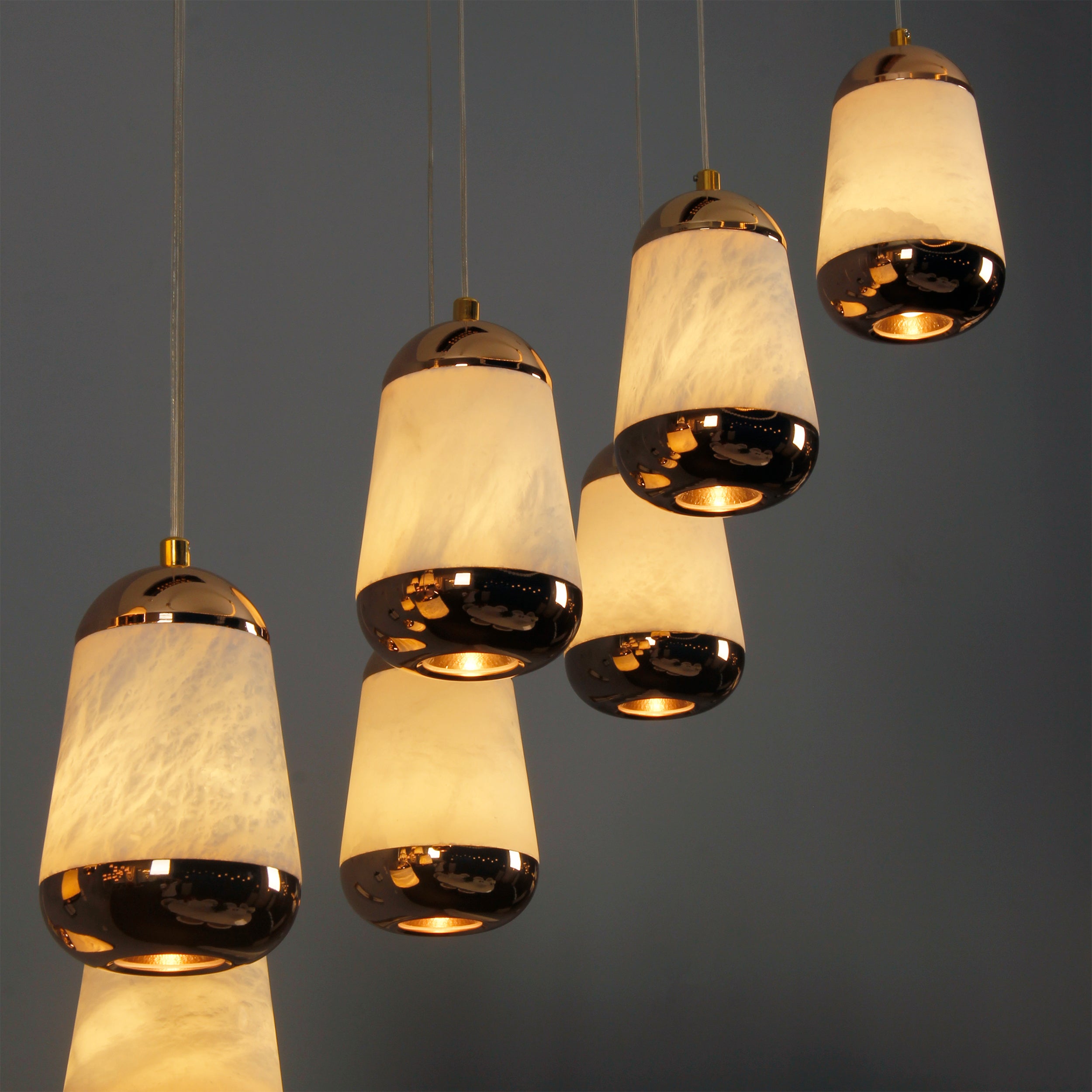 Detail of Giovanni marble-effect teardrop pendants emitting a warm ambient glow