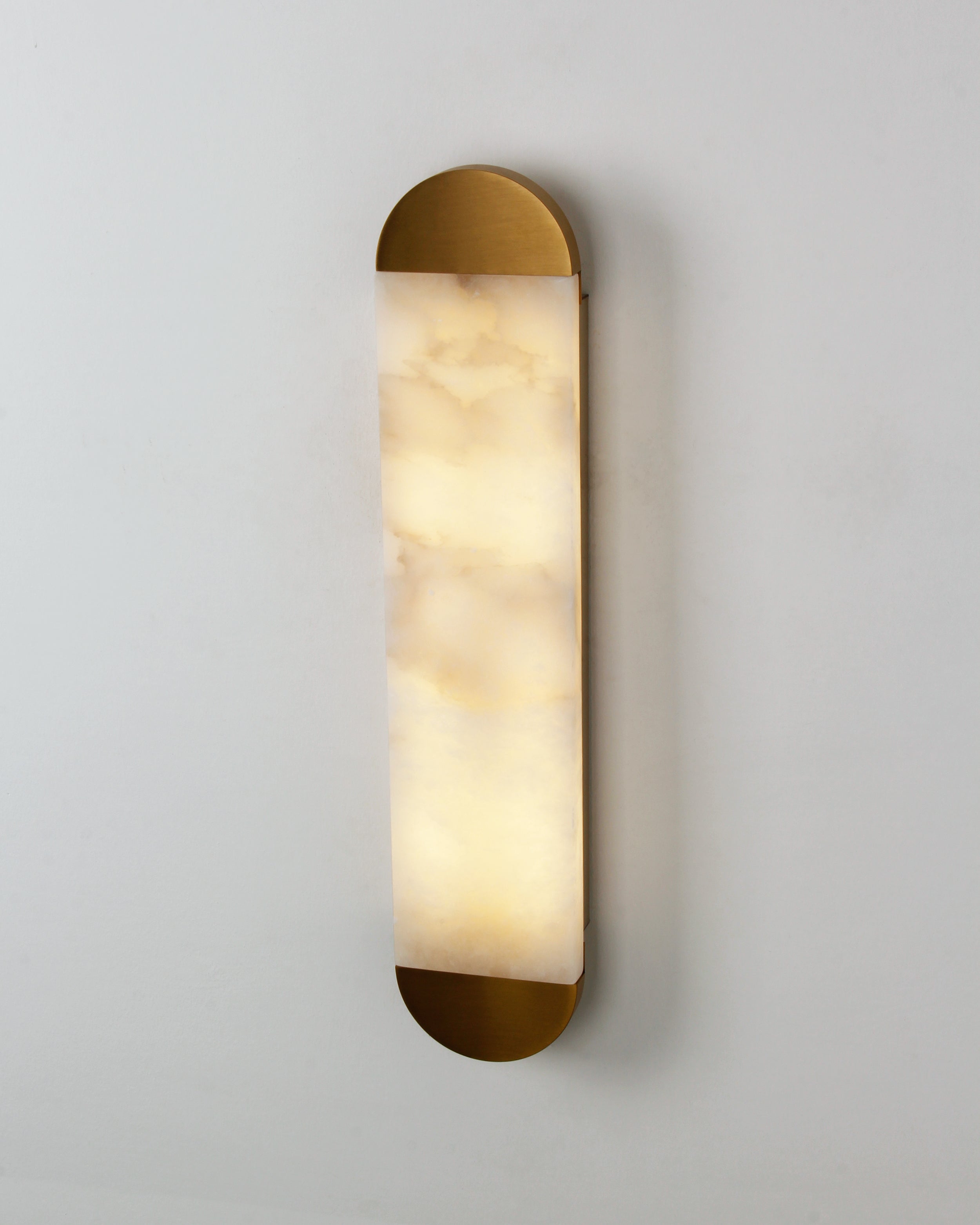 Front detail of rounded marble wall light with soft ambient glow
