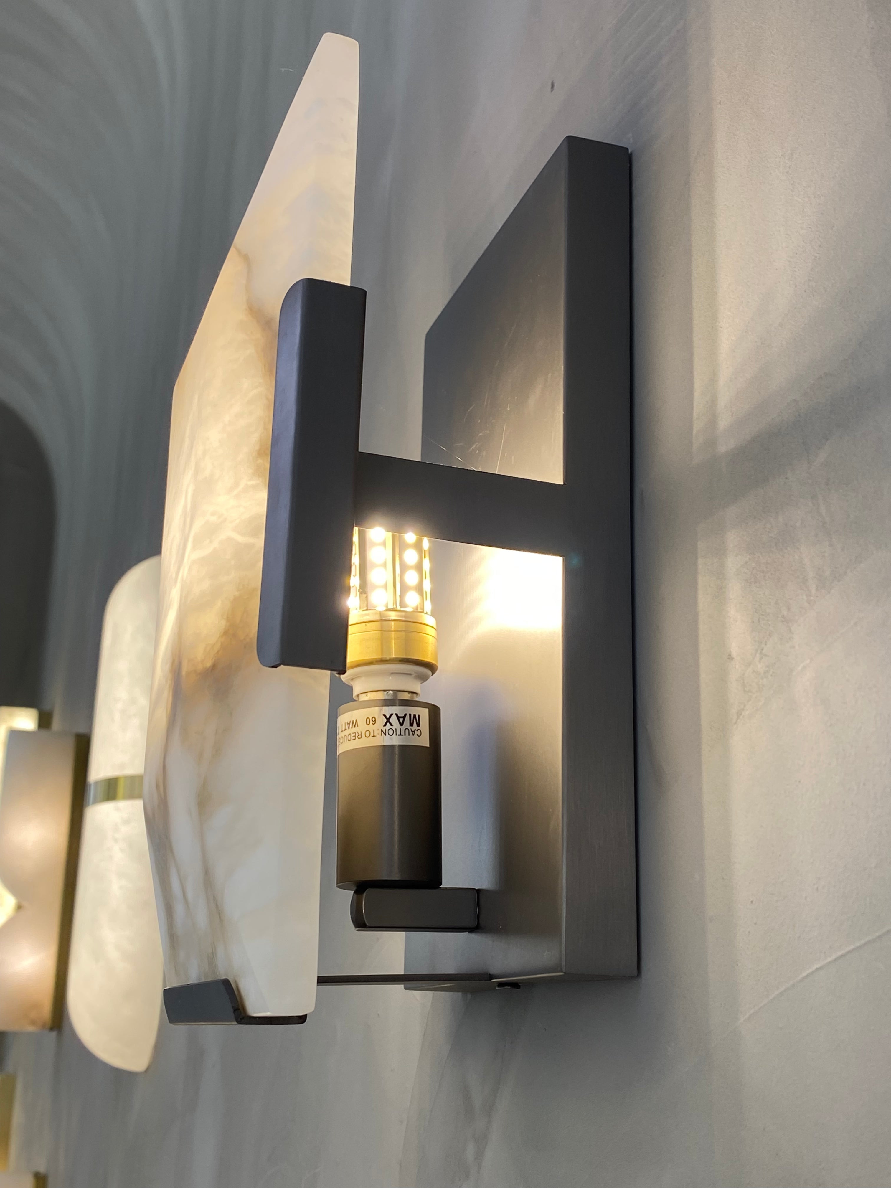 Close up of black frame and light source on Angel Marble Wall Light