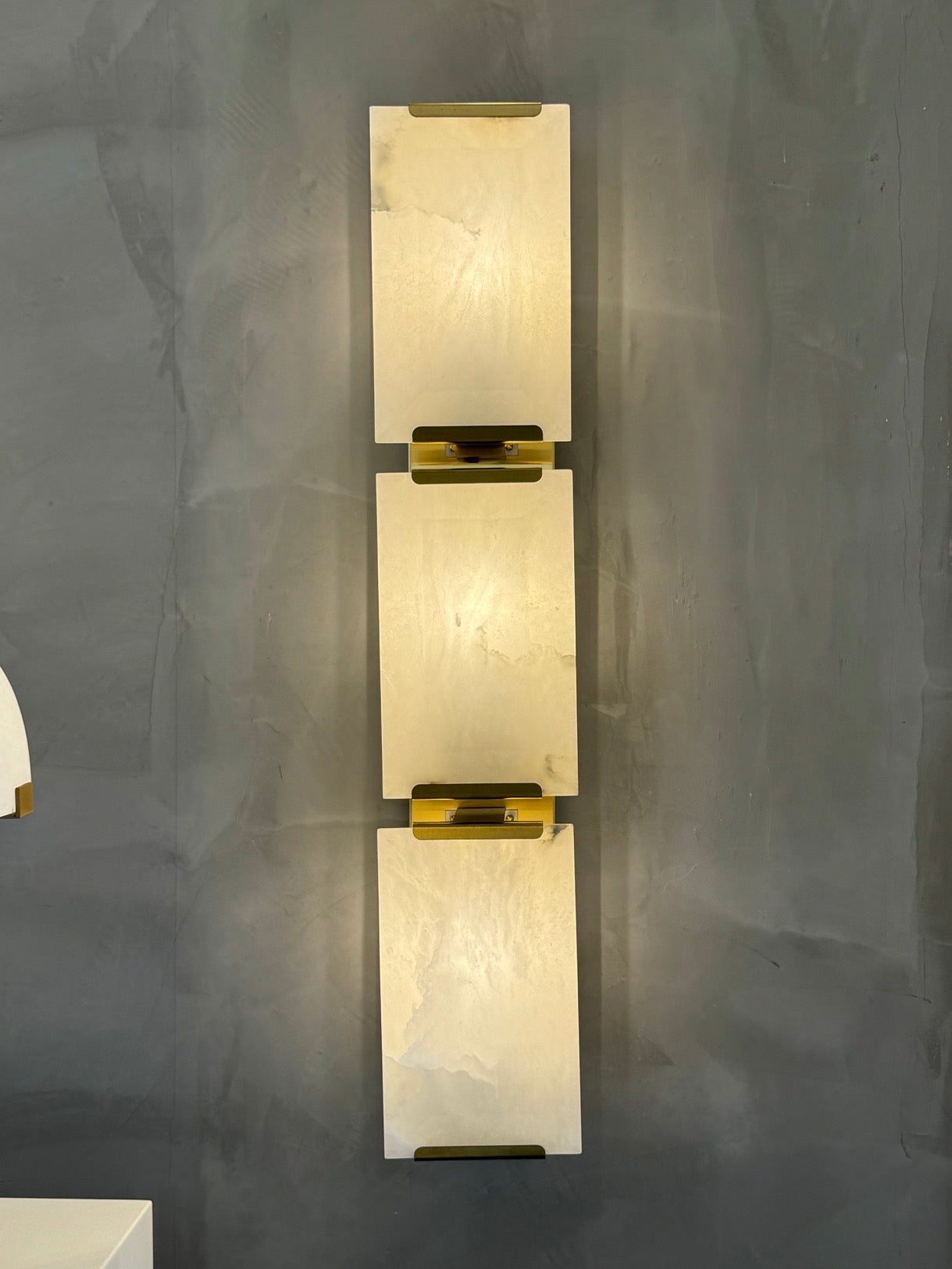 Front view of Angel Marble Wall Light II with warm ambient lighting