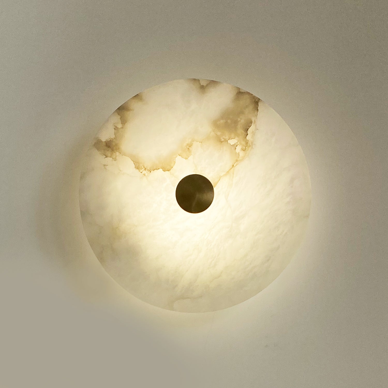 Close up of single Aria Marble Wall Light disc with brass centre
