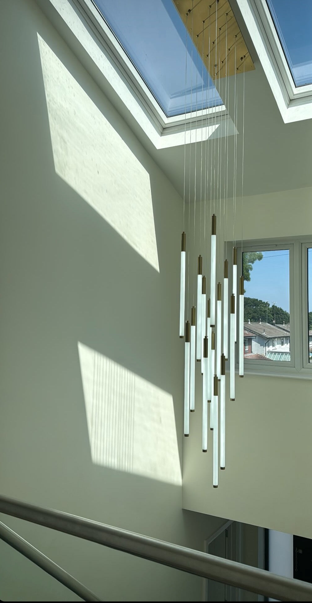 Avezzano pendant staircase chandelier installed in a double height modern stairwell