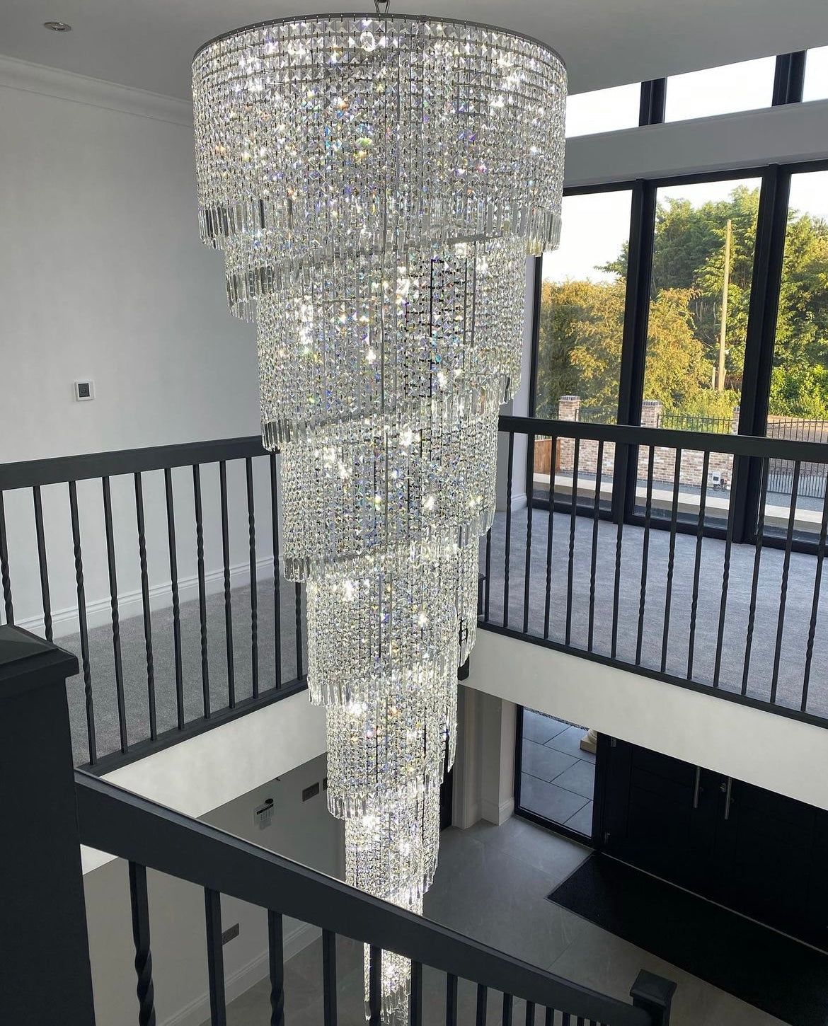 Basiglio crystal spiral chandelier installed in modern stairwell