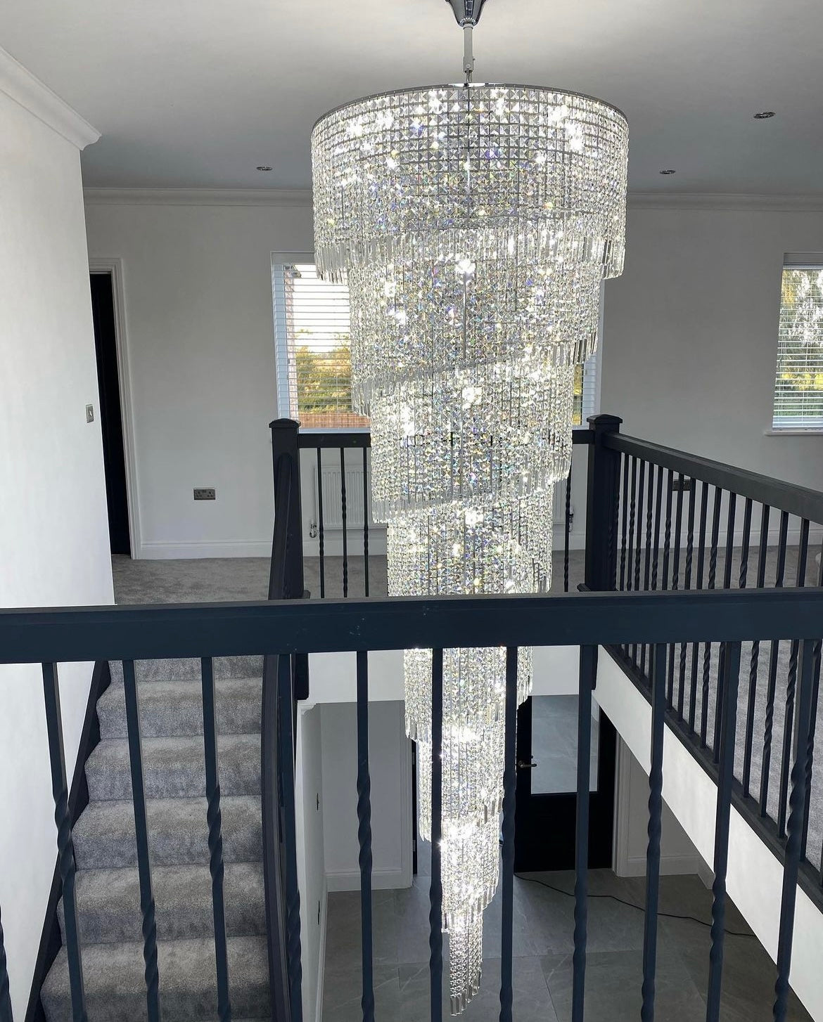 Mid-level view of Basiglio spiral crystal chandelier in stairwell