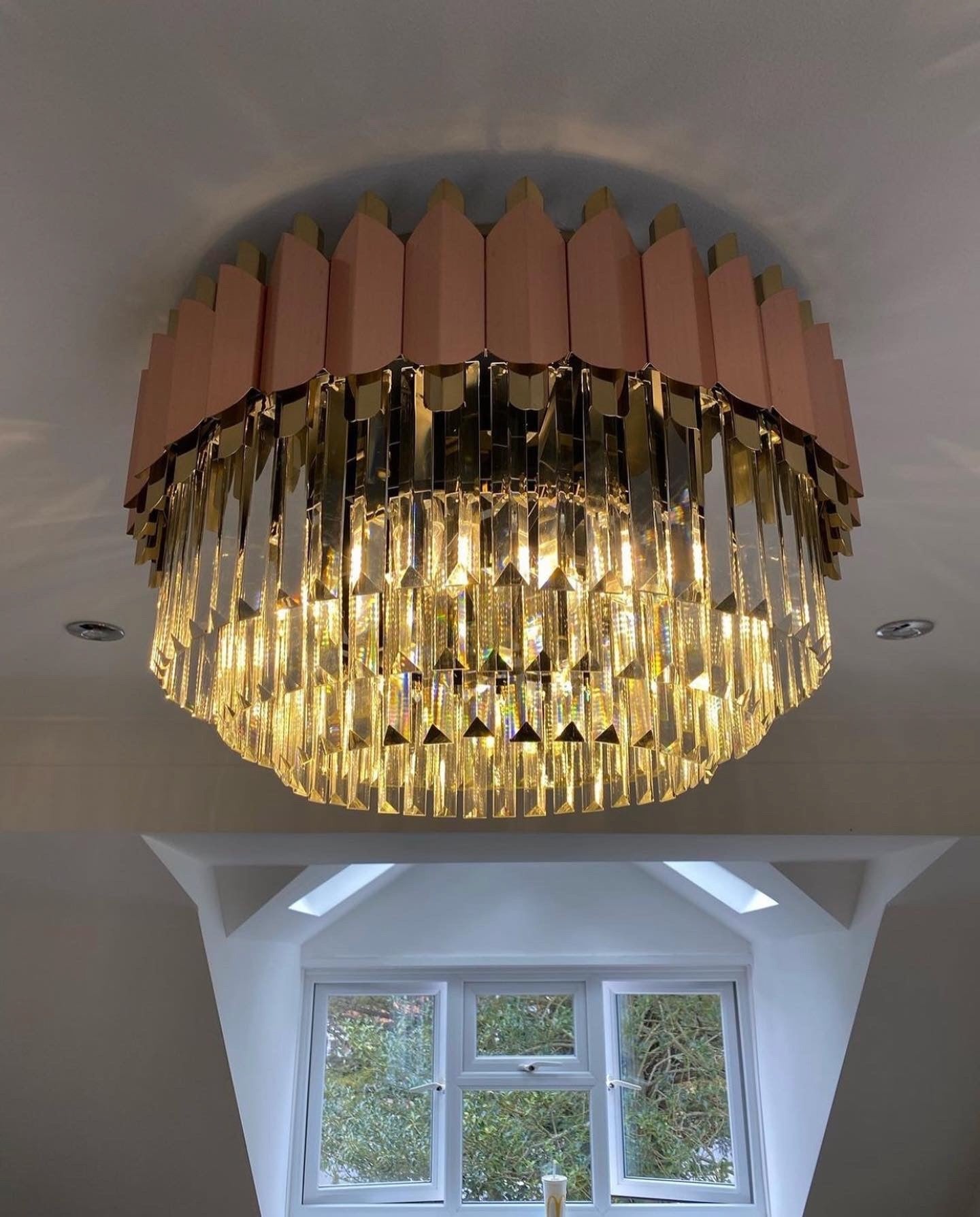 Bianca circular chandelier casting warm ambient light from ceiling