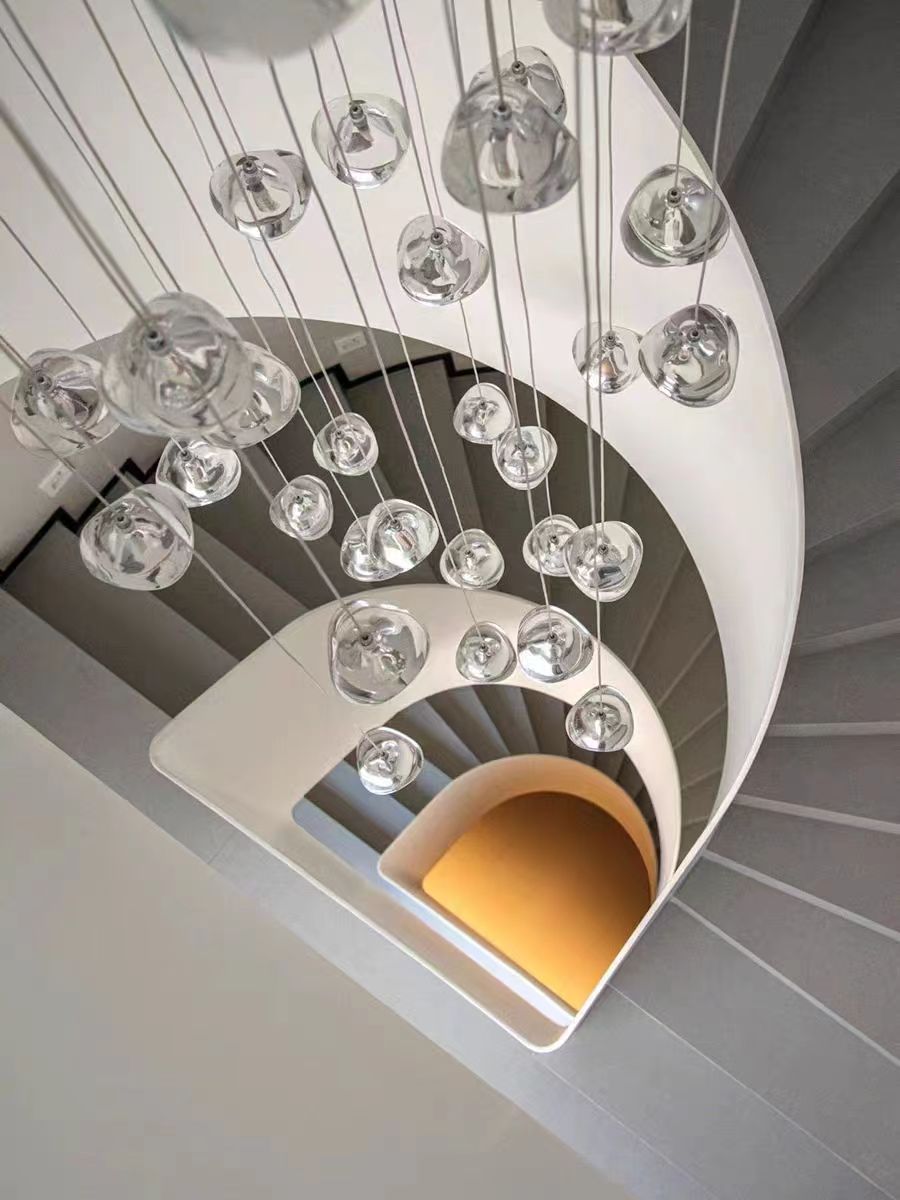 Biella cascading glass chandelier installed in curved staircase