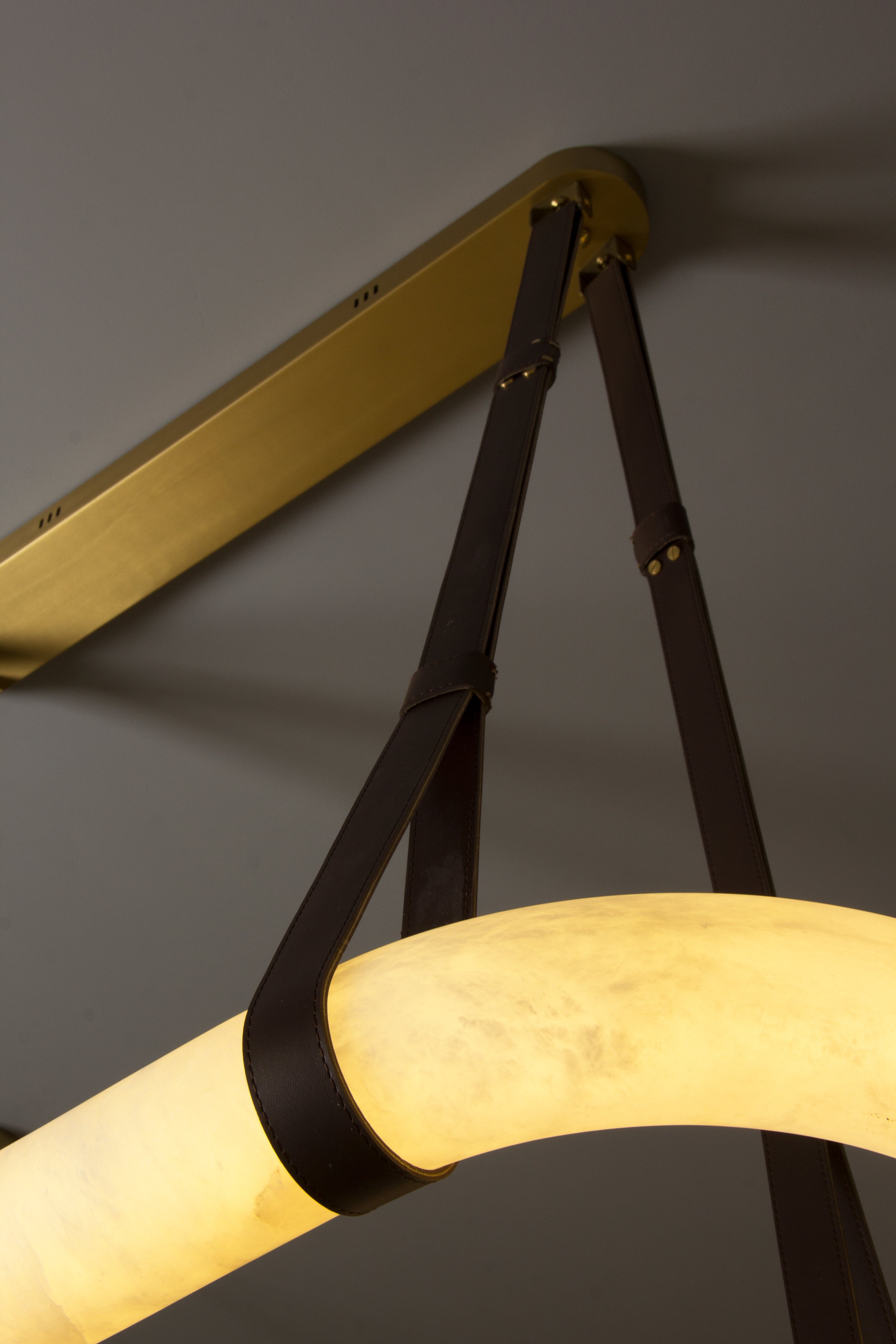 Close-up of leather strap suspension on Botticino marble chandelier