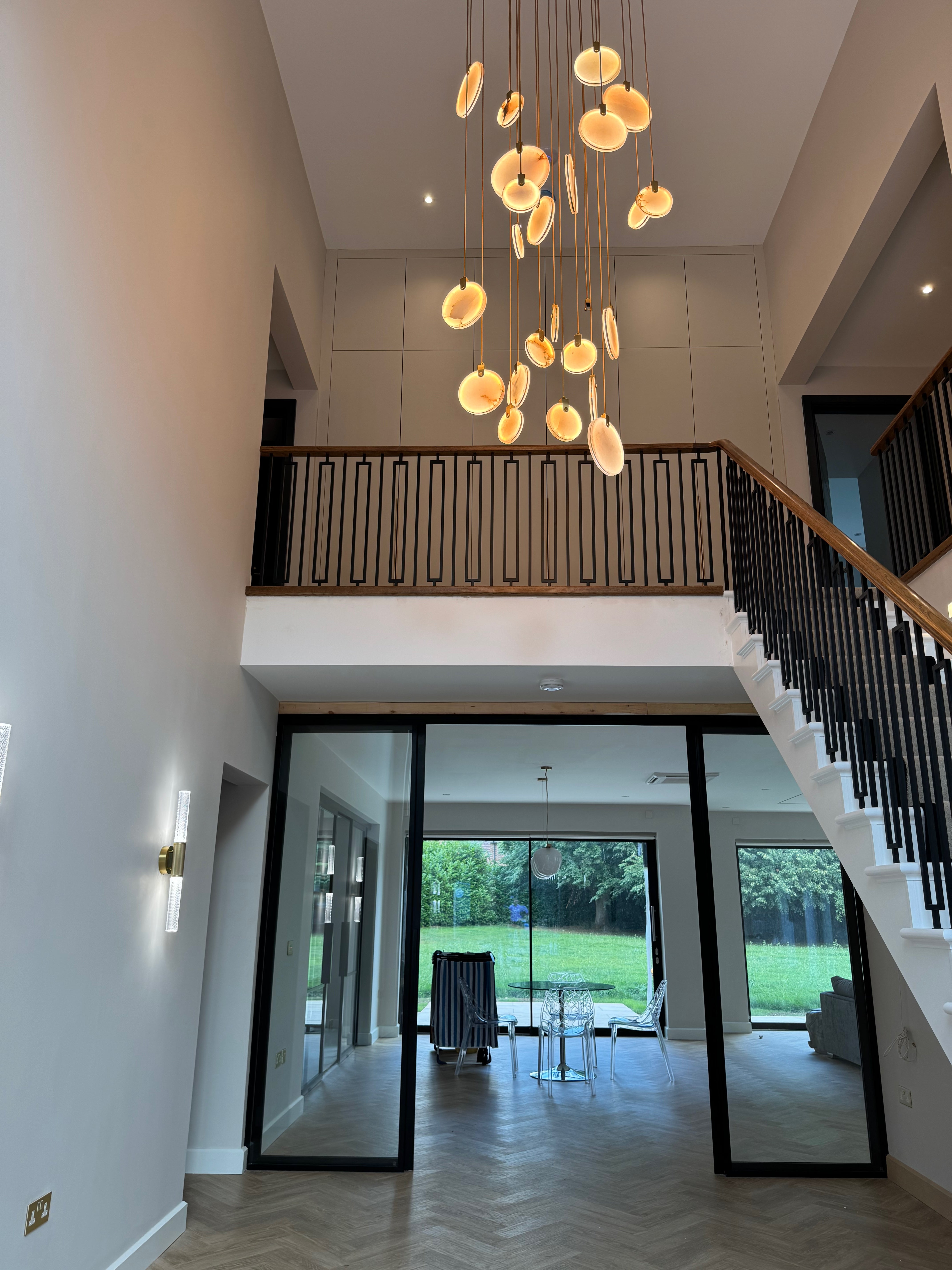 Luxury Calacatta marble chandelier framed within a modern staircase architectural opening.