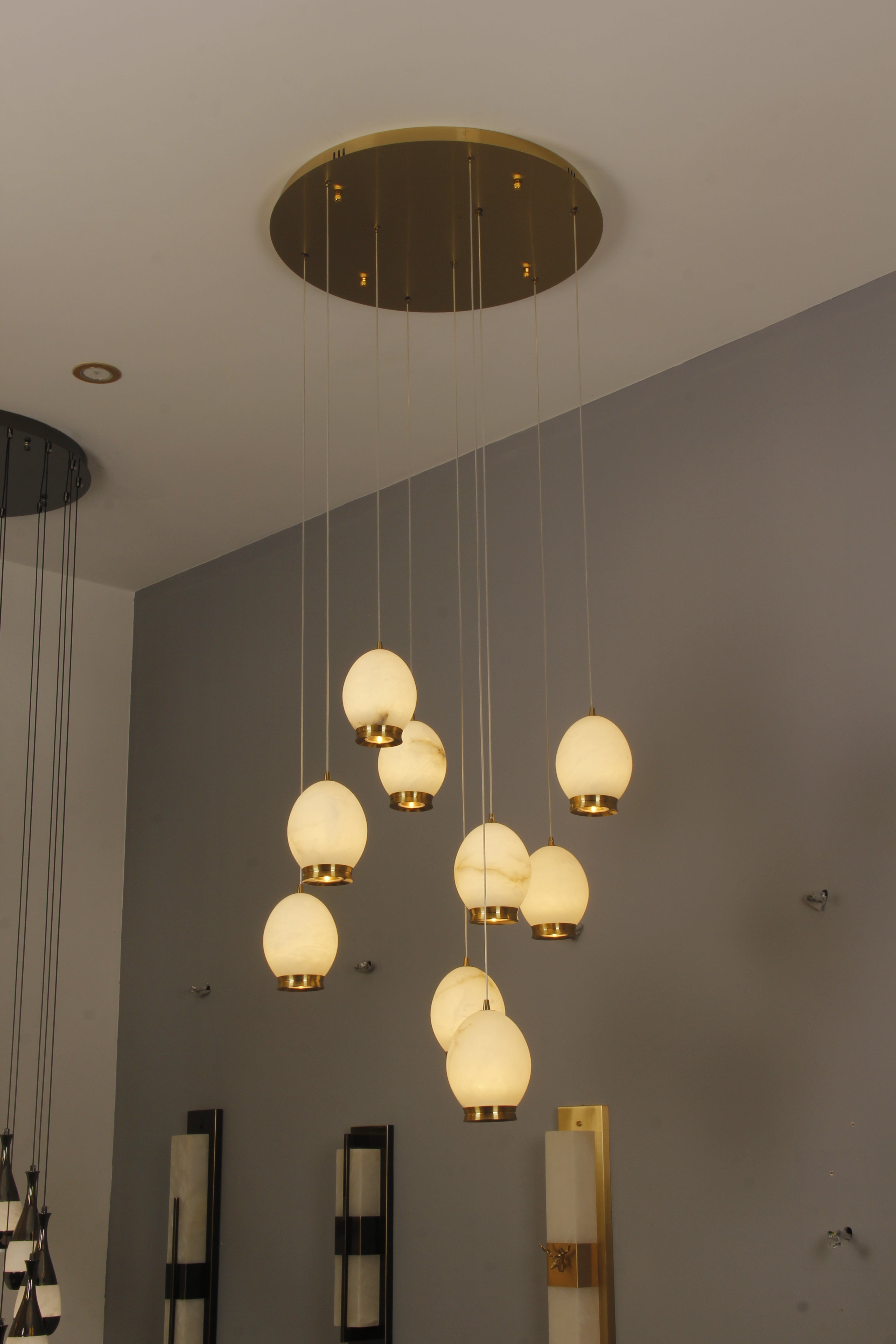 Marble staircase chandelier creating statement lighting in modern interior