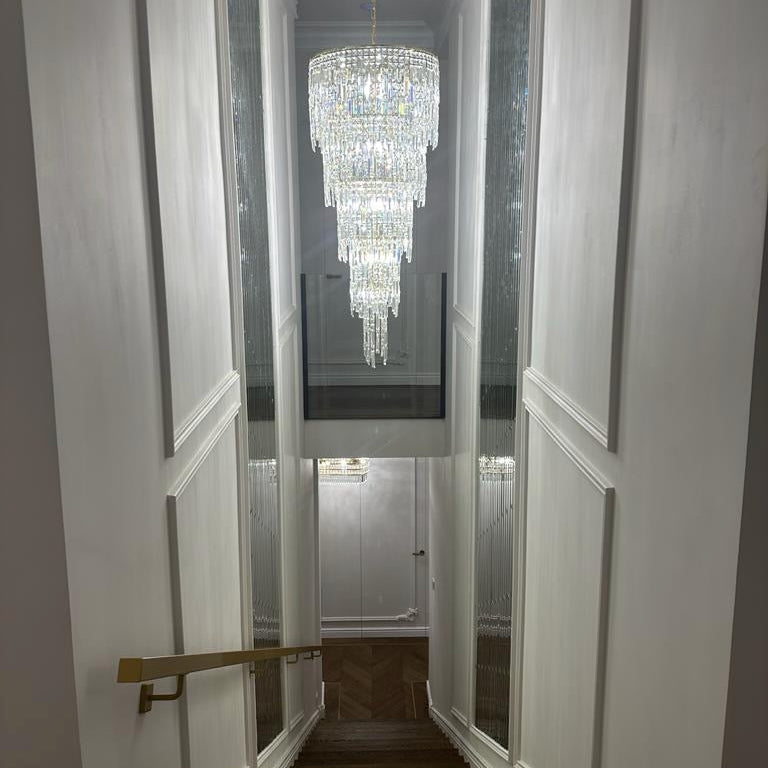Double height spiral crystal chandelier in modern UAE stairwell