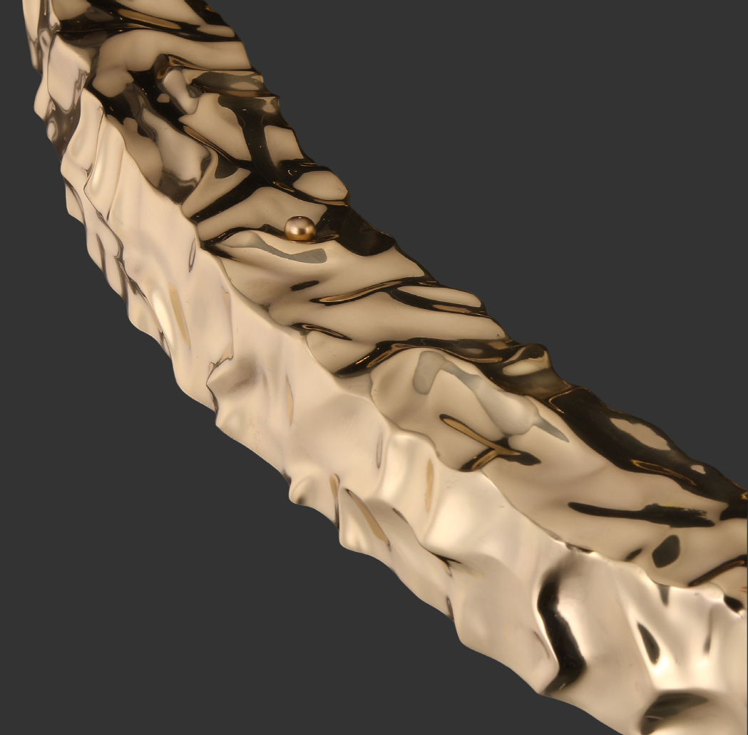 Close-up of the textured gold ring detailing on the Ecliptica staircase chandelier by VORELLI®