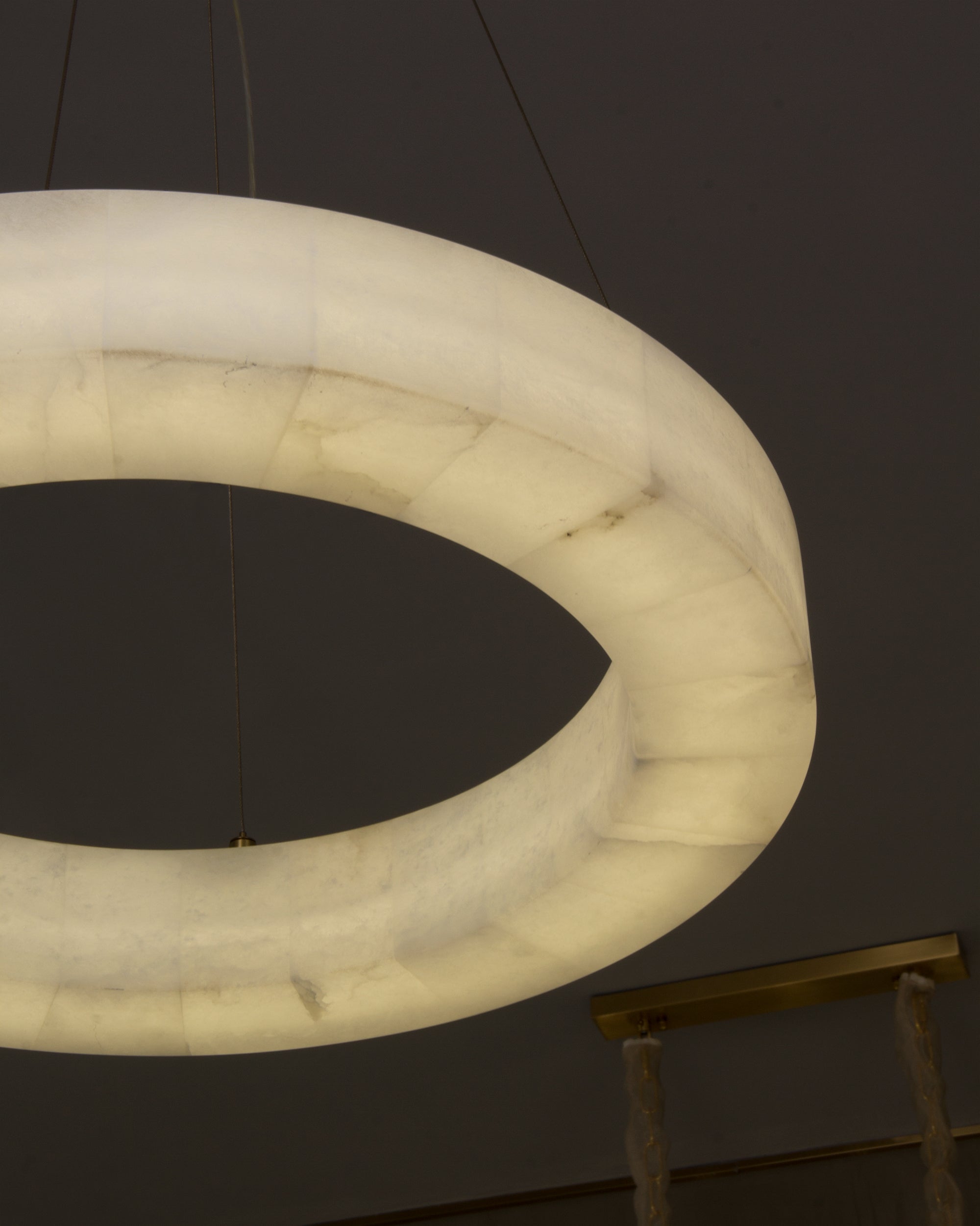 Close-up of softly veined marble illuminated within the Halo Marble Circular Chandelier