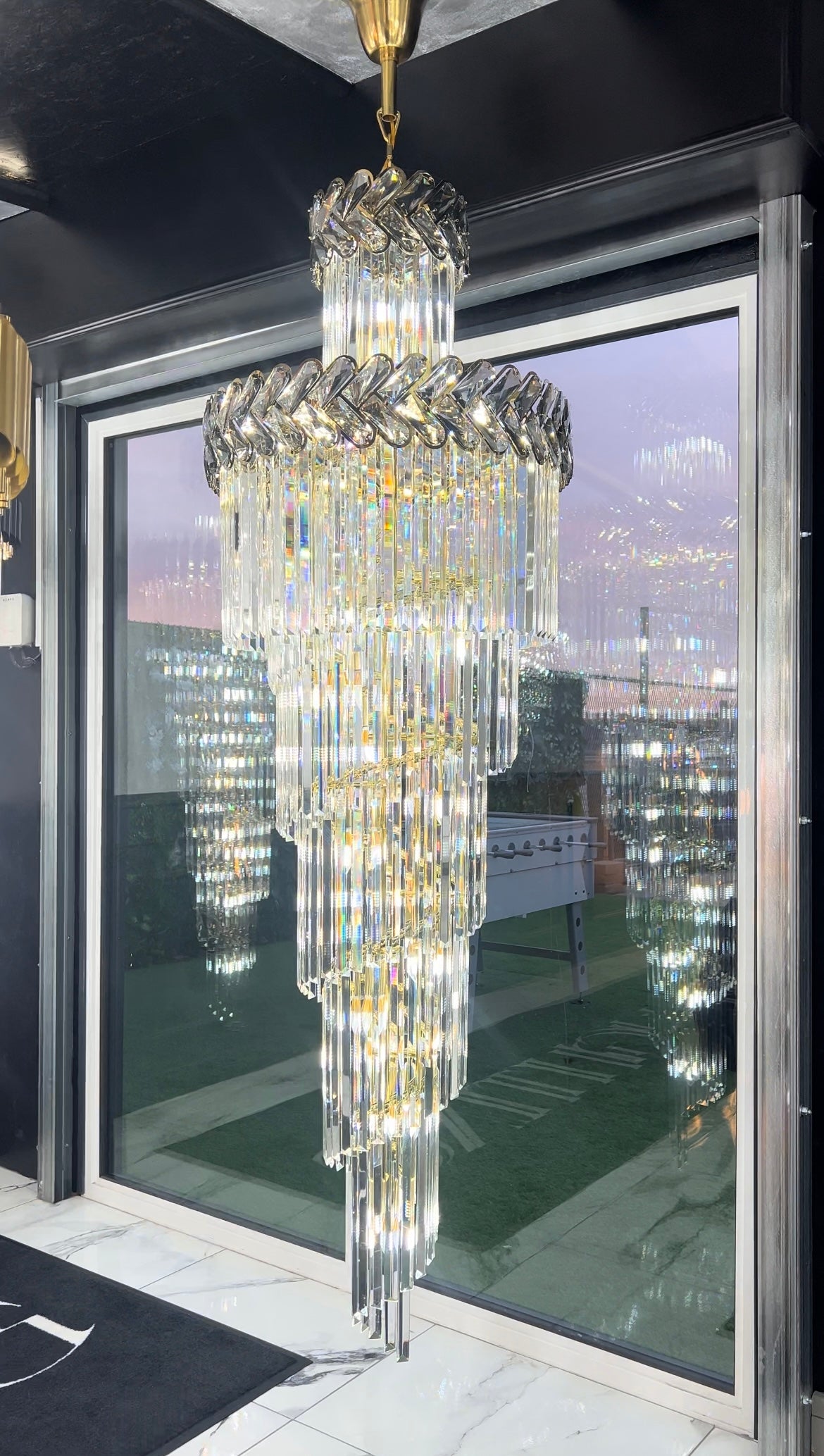 Luxury spiral crystal chandelier suspended in tall entrance interior