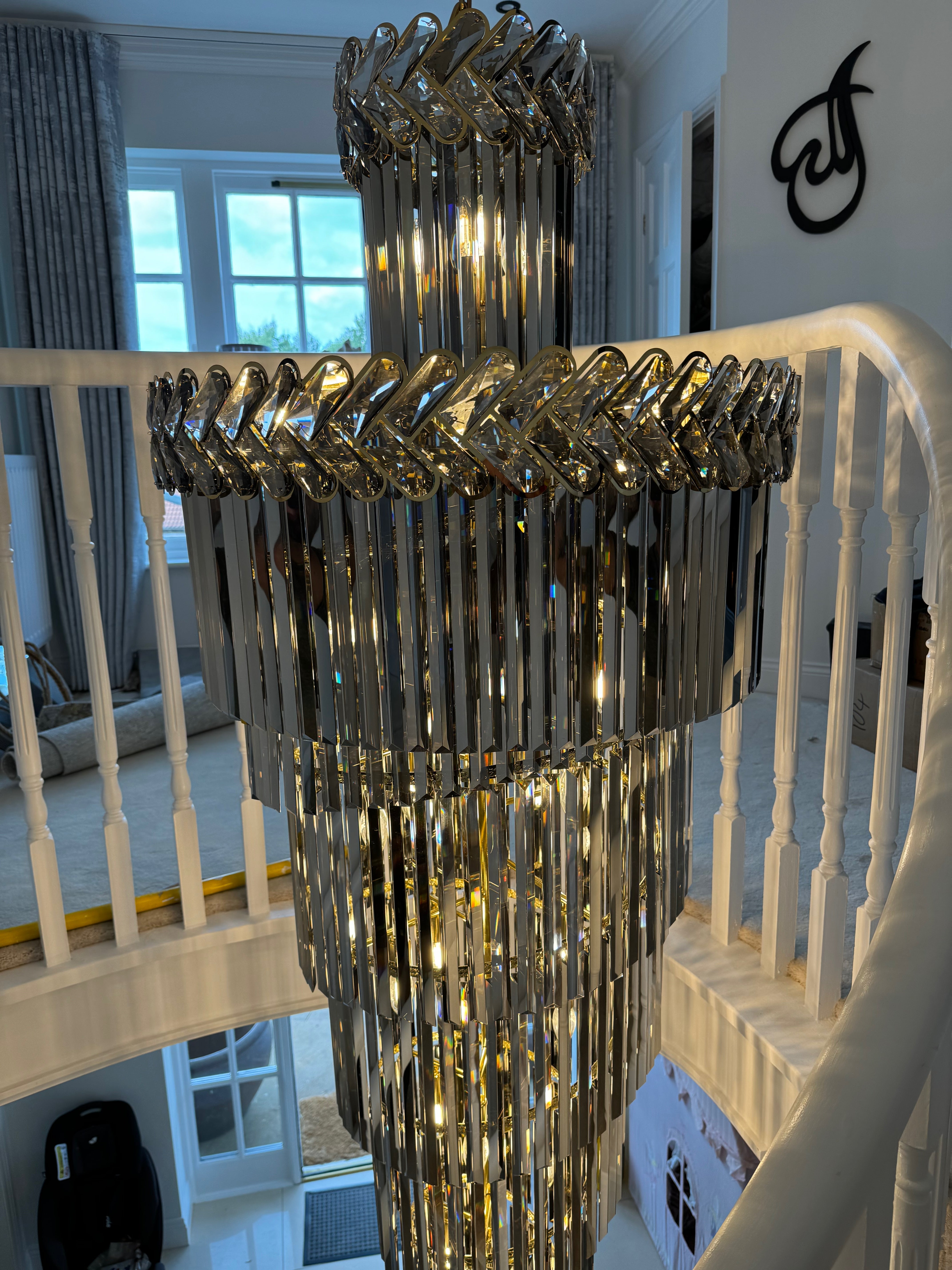 Knightsbridge spiral crystal chandelier reflected in mirrored staircase wall within a modern luxury home