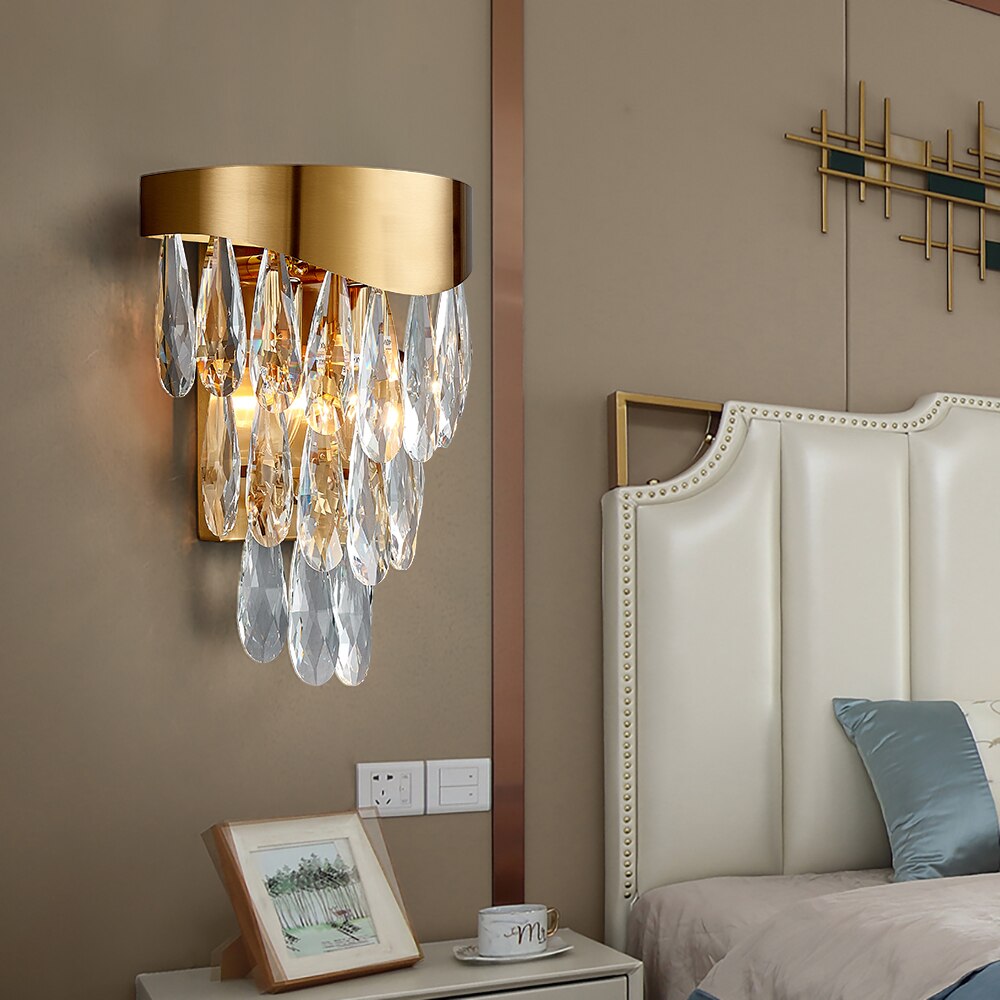 Luxury crystal wall light installed beside a bed creating warm ambient illumination