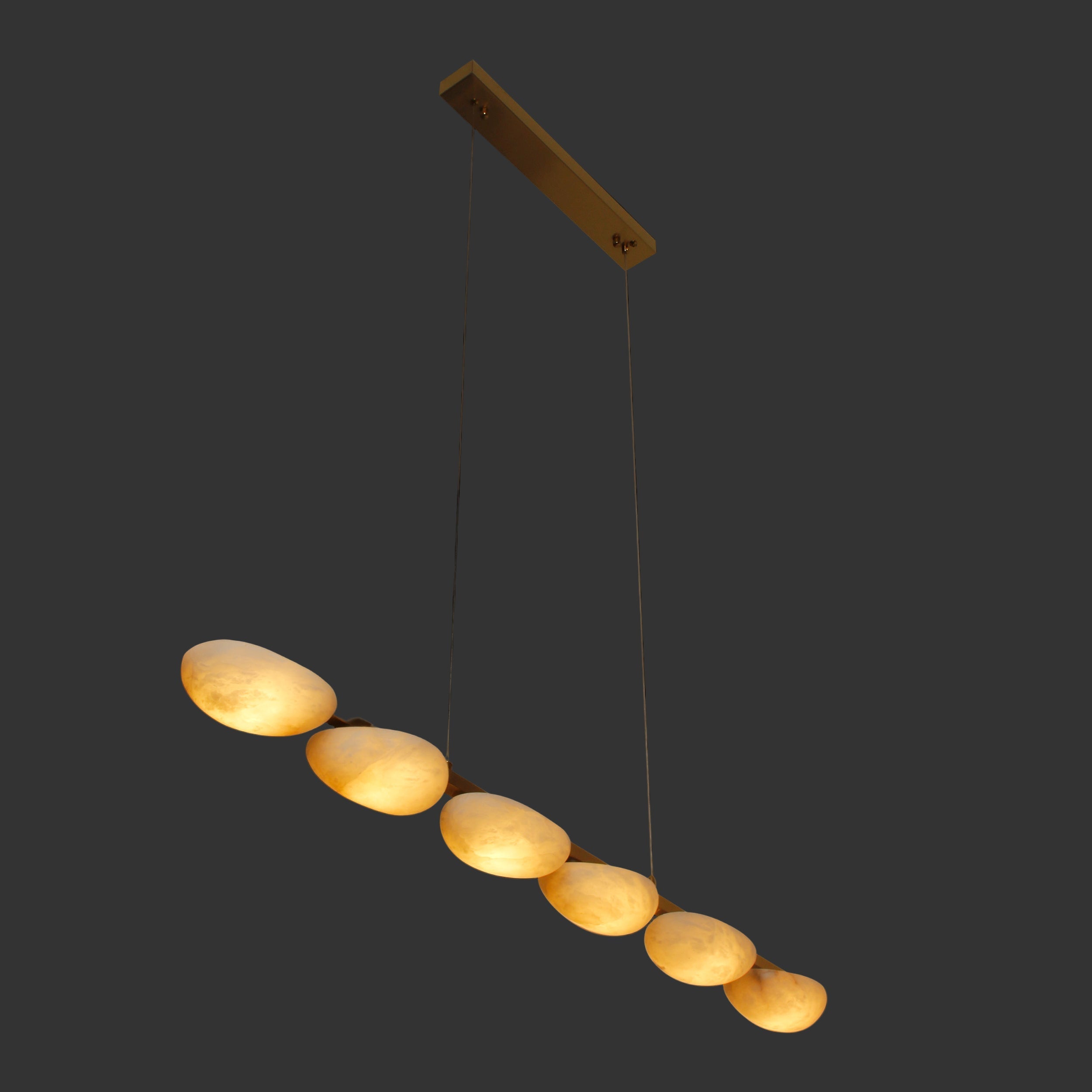 Luxury marble linear chandelier illuminated against dark background