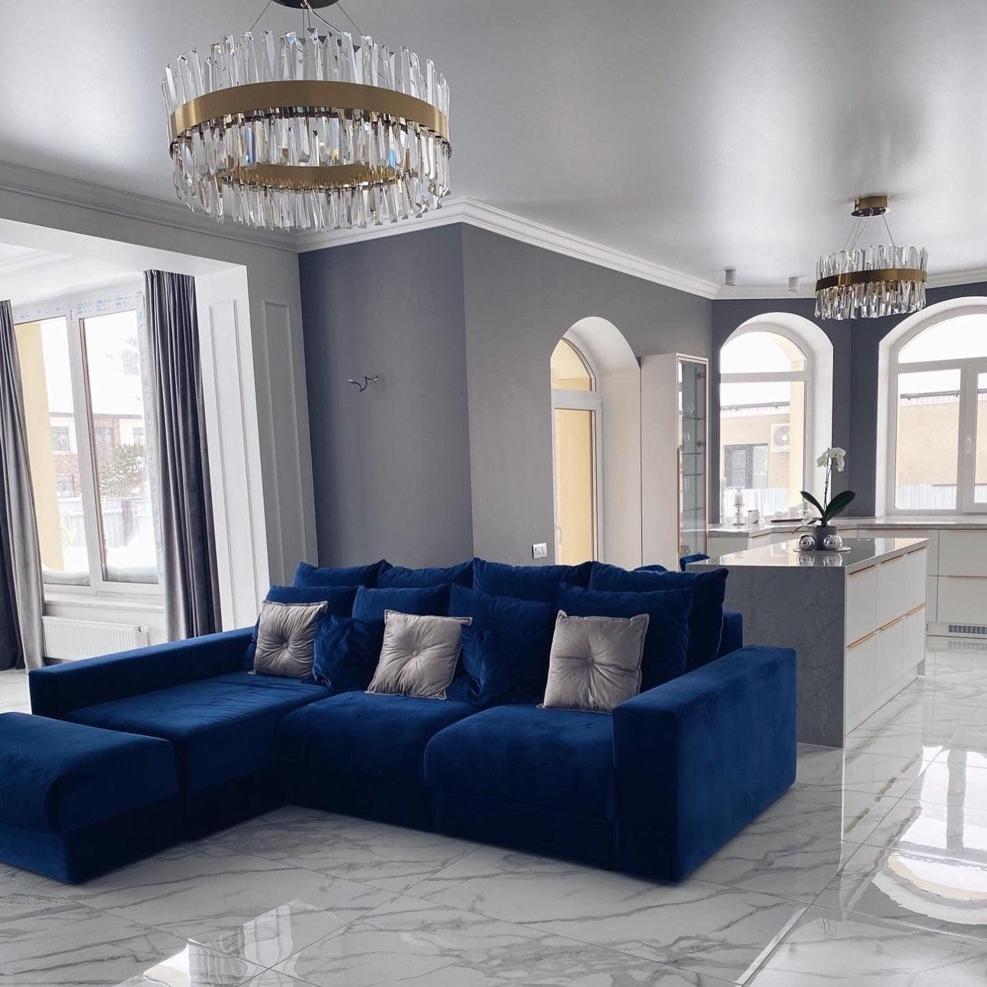Modern circular crystal chandelier installed in a bright open-plan residential interior