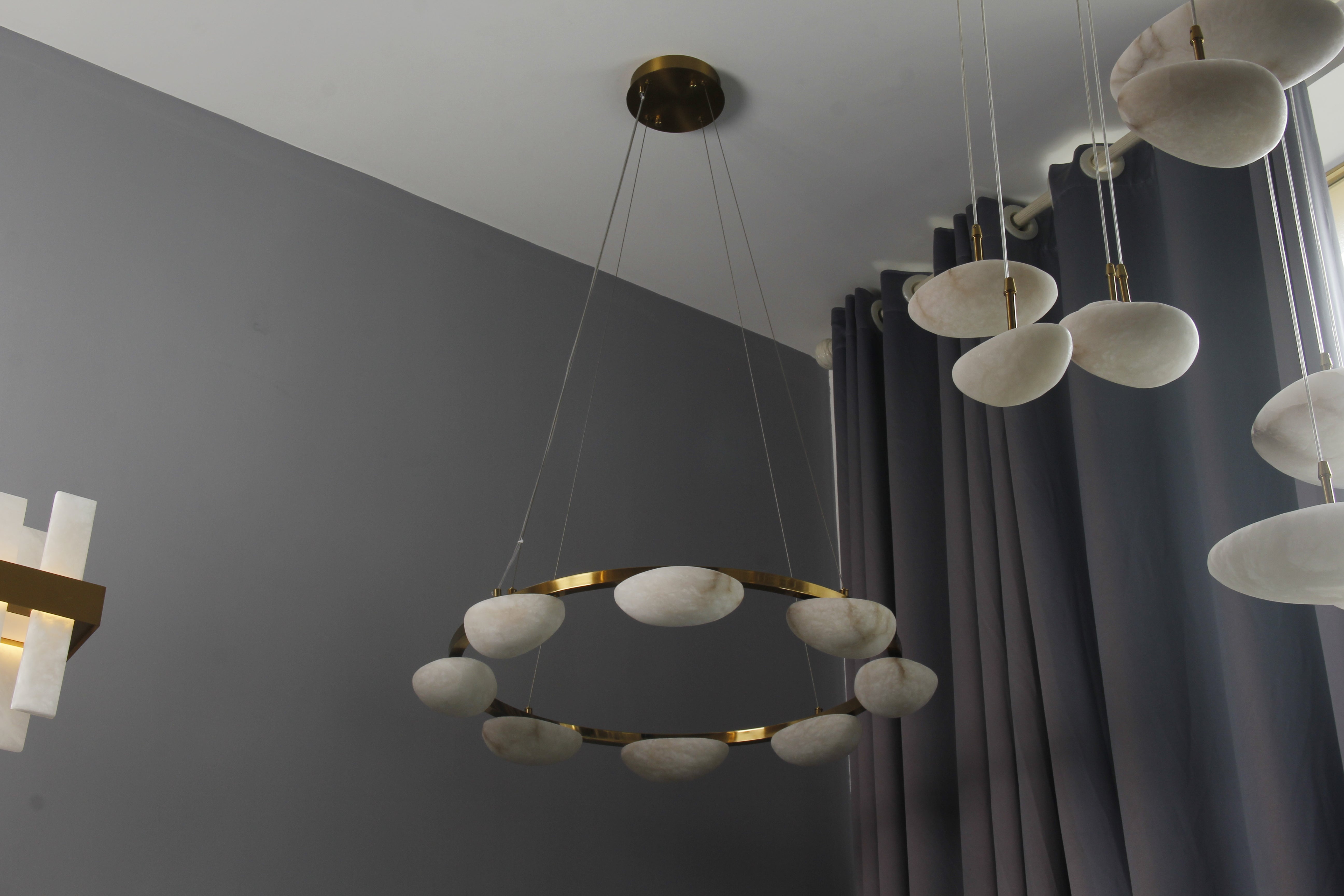 Marble circular chandelier installed above dining table in Dubai home