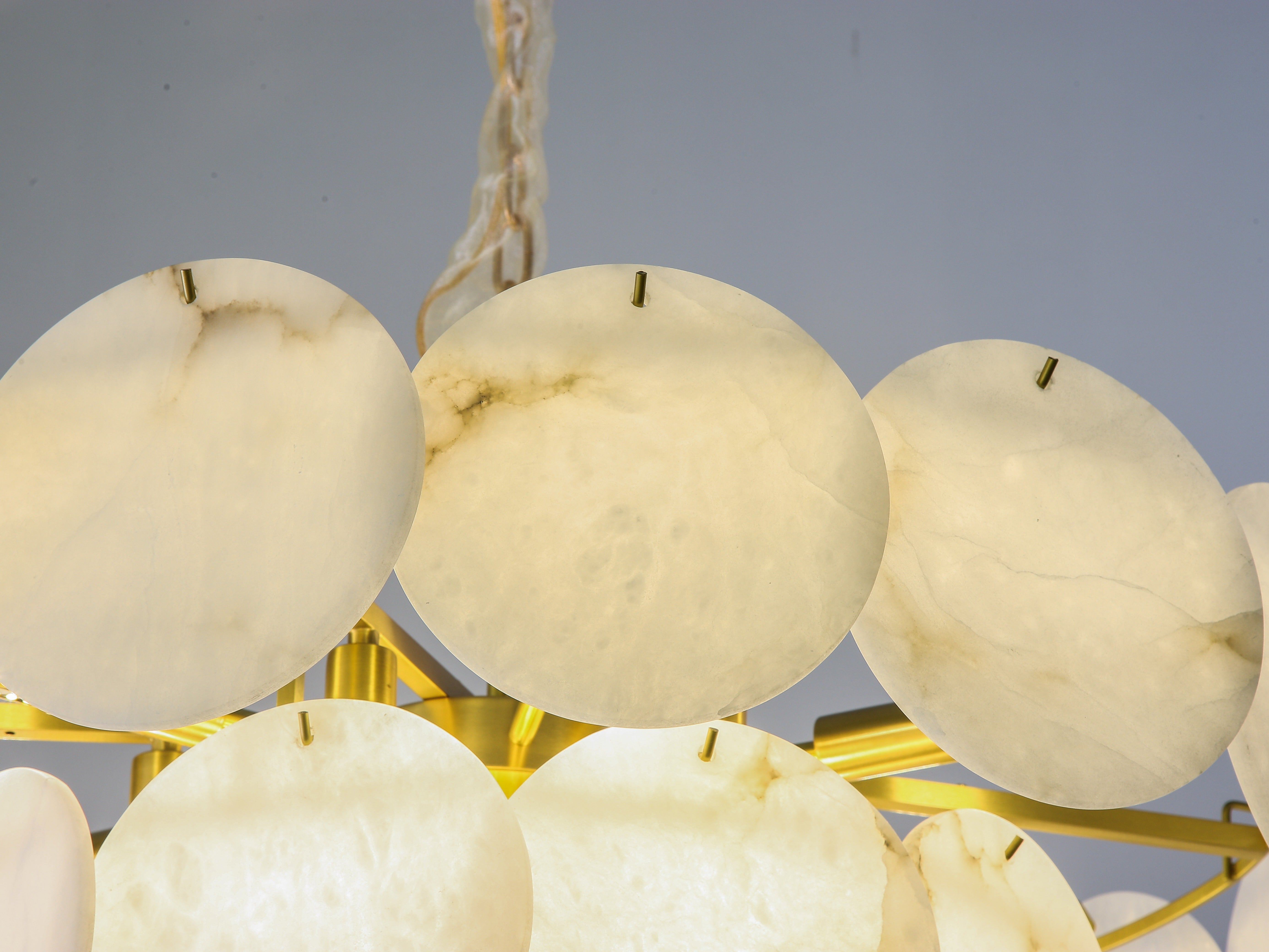 Close up of layered marble discs on circular chandelier in Dubai interior