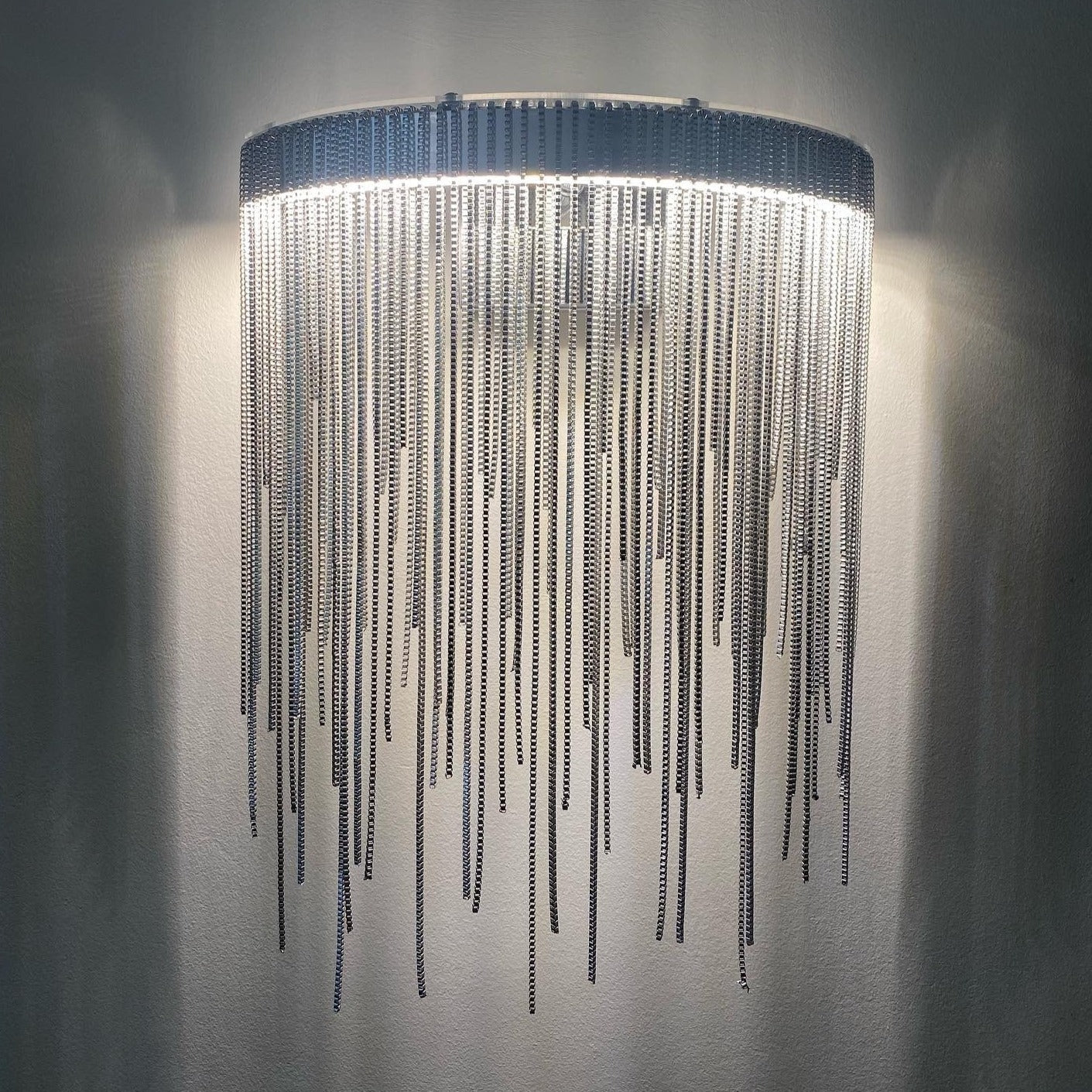 Modern cascading chain wall light illuminated in Dubai interior