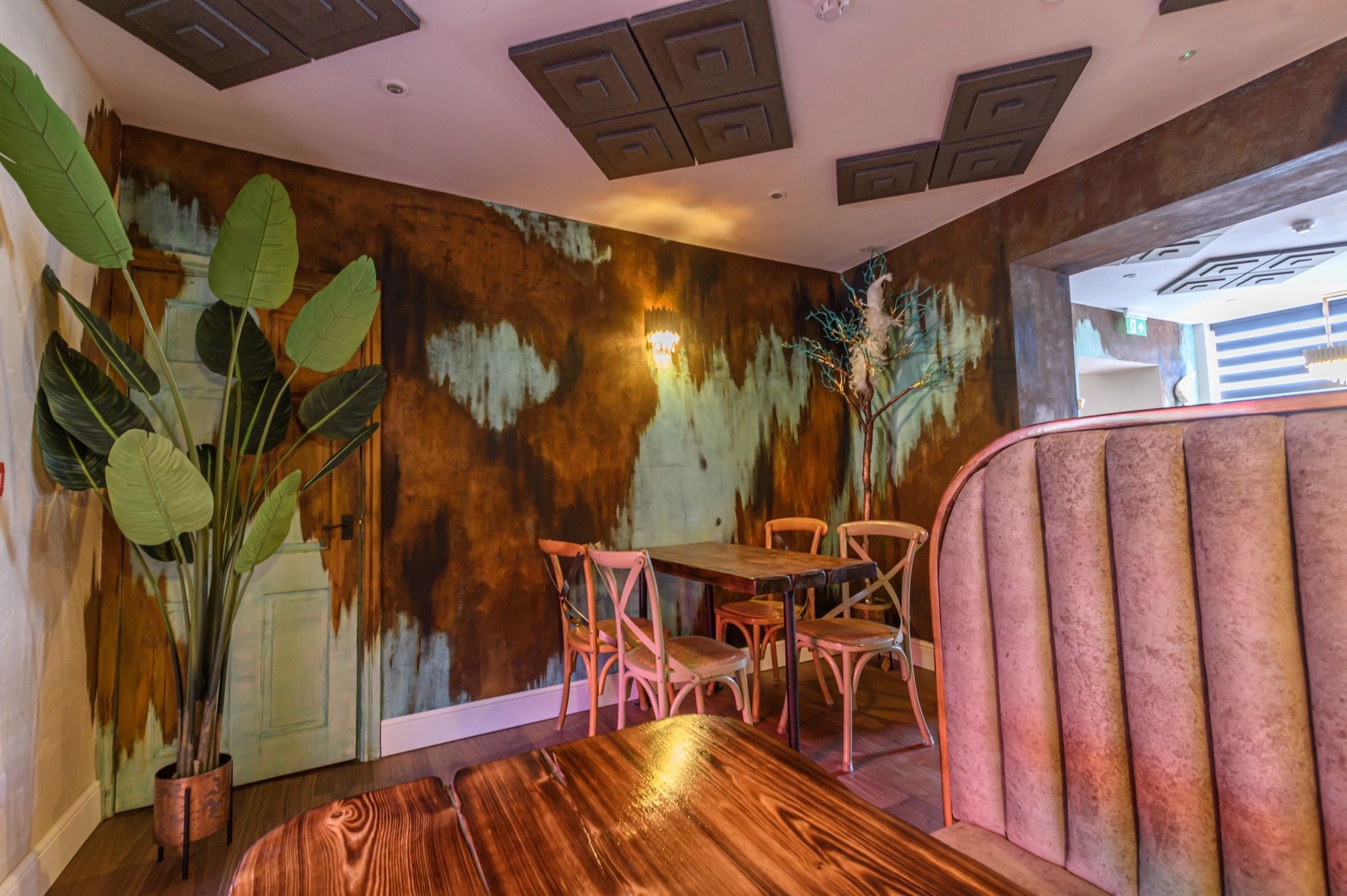 VORELLI Doral wall light illuminating luxury restaurant seating area with warm ambient glow
