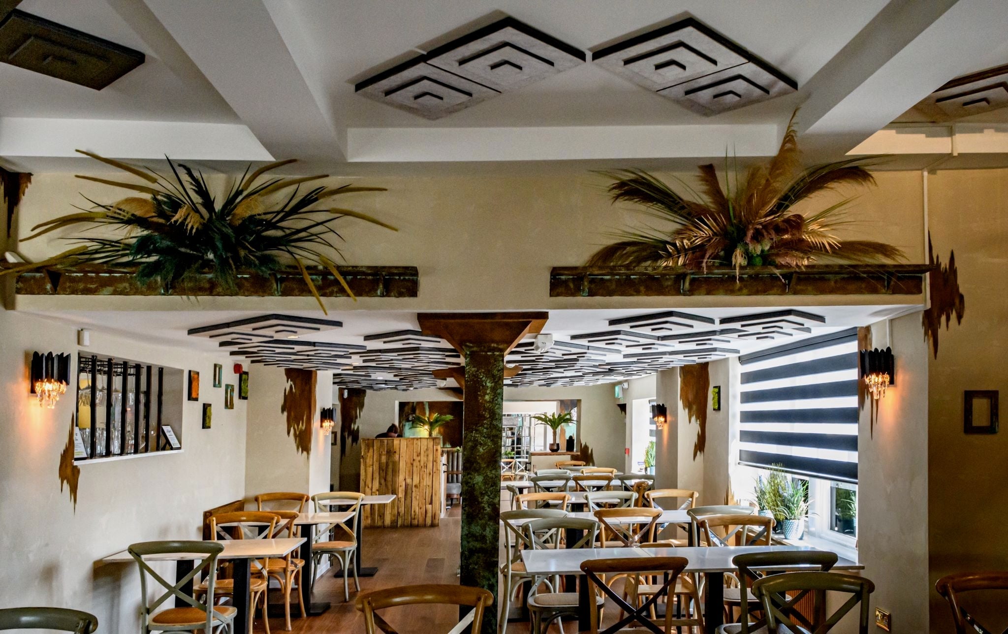 Wide restaurant interior featuring multiple VORELLI Doral wall lights creating ambient lighting