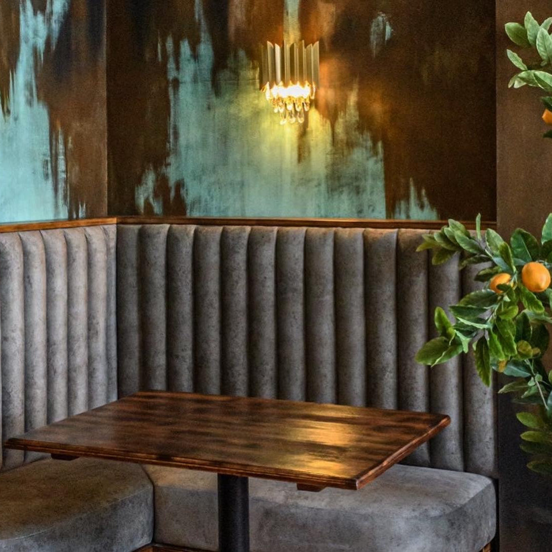VORELLI Doral wall light highlighting textured feature wall in boutique restaurant