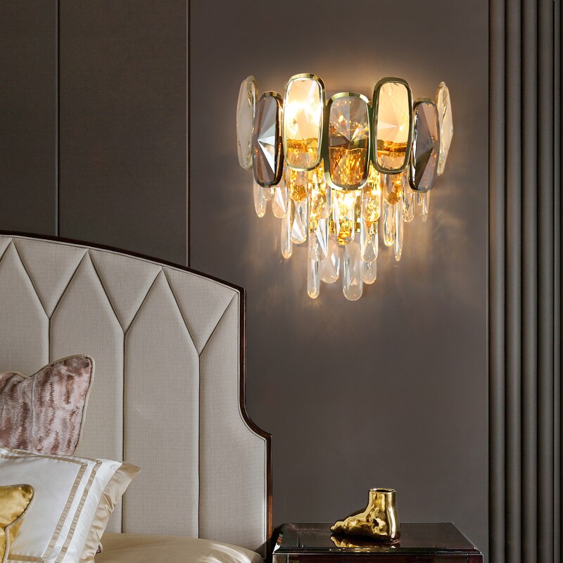 Edmond wall light with oblong diamond cut crystals beside a luxury upholstered bed
