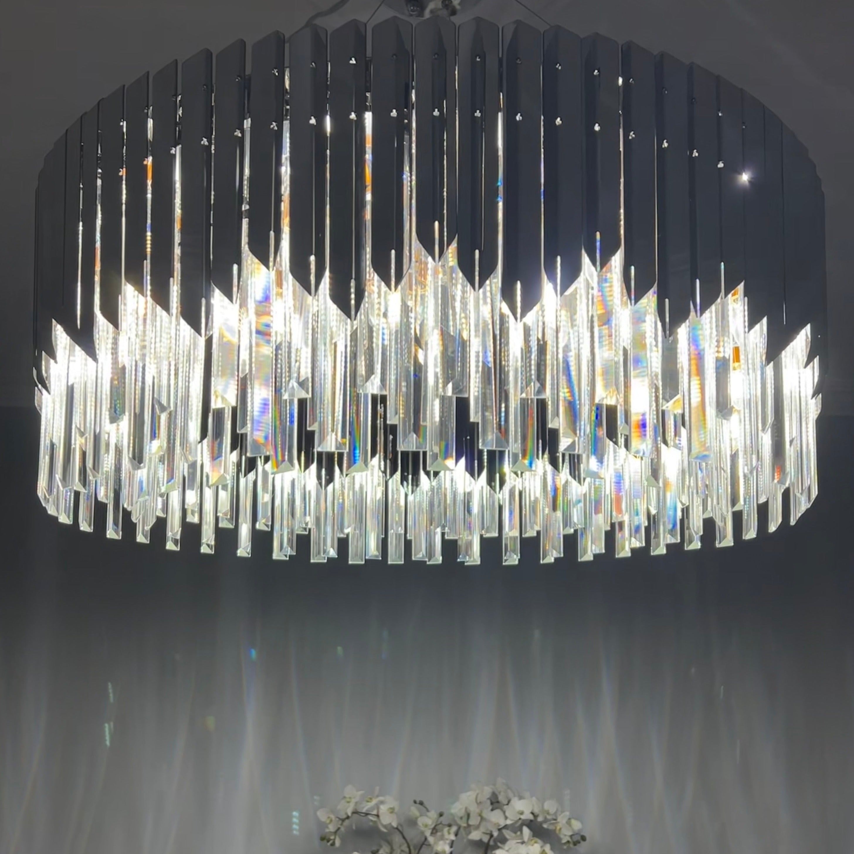 Detailed view of VORELLI Manhattan chandelier diamond-cut crystal bars emitting warm light