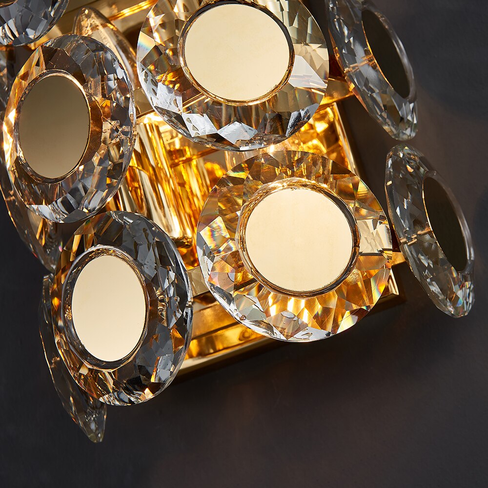 Detailed angled view of illuminated crystal discs on the VORELLI Manzoni luxury wall light