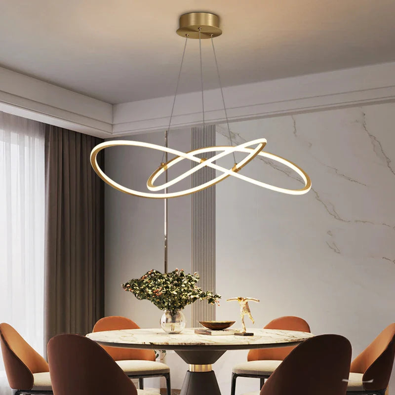 VORELLI Milano circular LED chandelier with sculptural rings suspended above a modern dining table