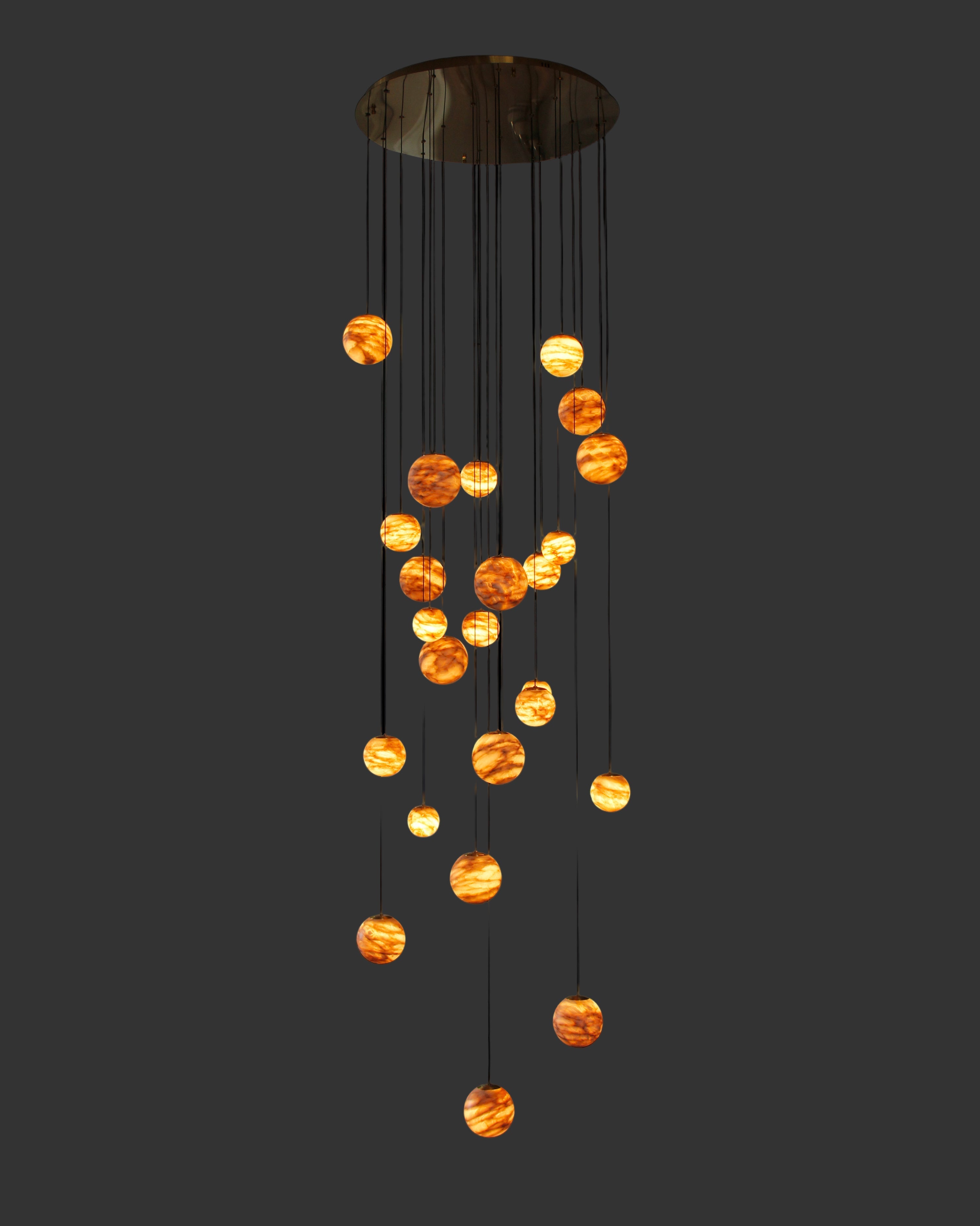 Luxury marble stairwell chandelier by VORELLI® featuring suspended illuminated spheres designed for double-height residential and hospitality spaces