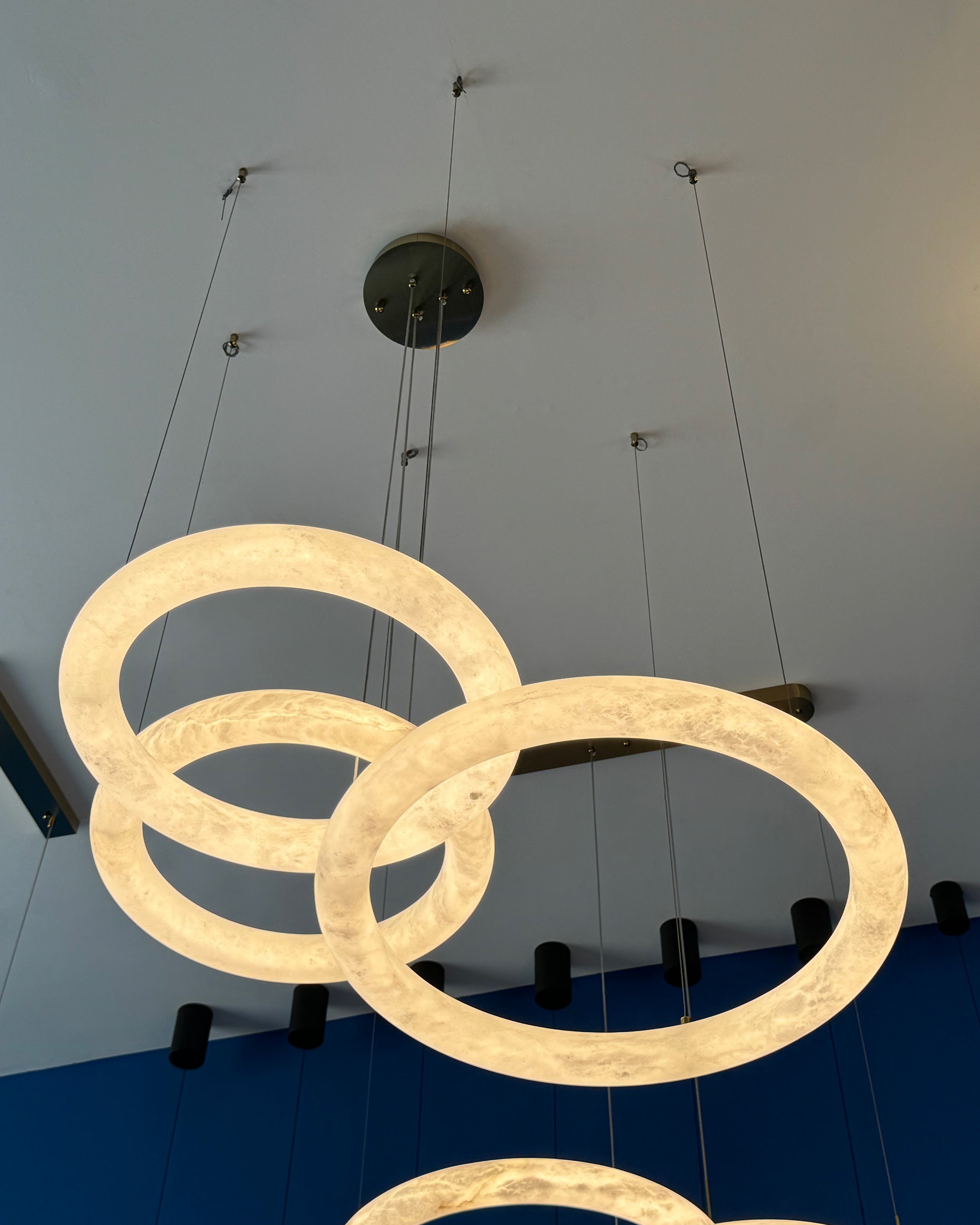 Upward perspective of the Cavani Marble Trio Circular Chandelier showcasing its suspended sculptural rings.