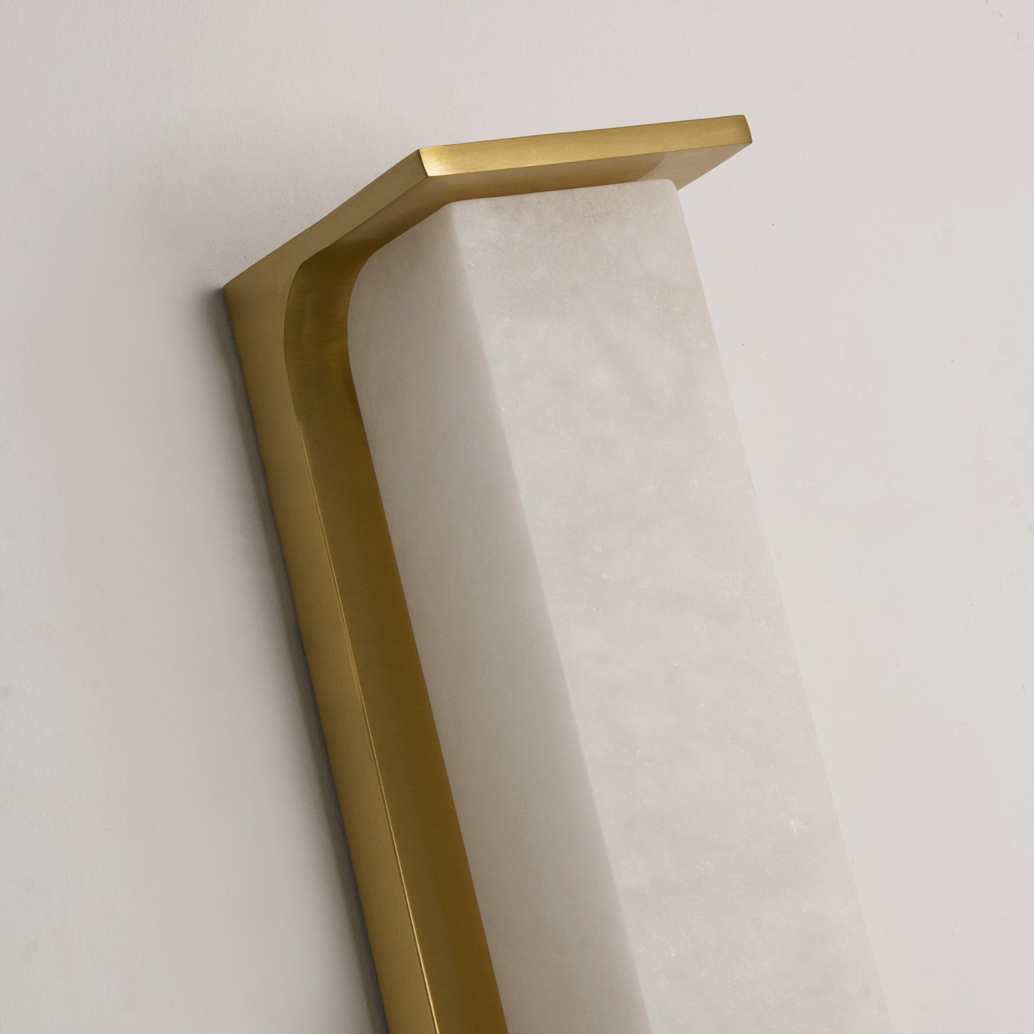 Close-up of the upper metal frame and marble junction on the VORELLI Matera wall light revealing precision craftsmanship and premium materials
