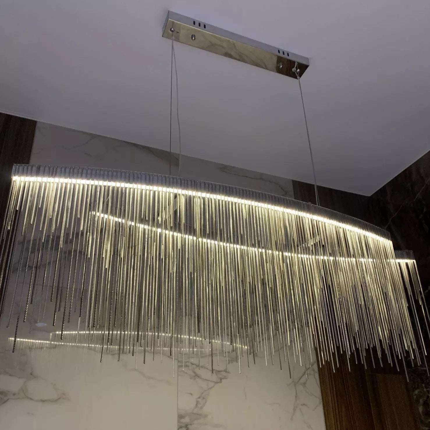Close view of cascading illuminated chains on Adlington Arc chandelier