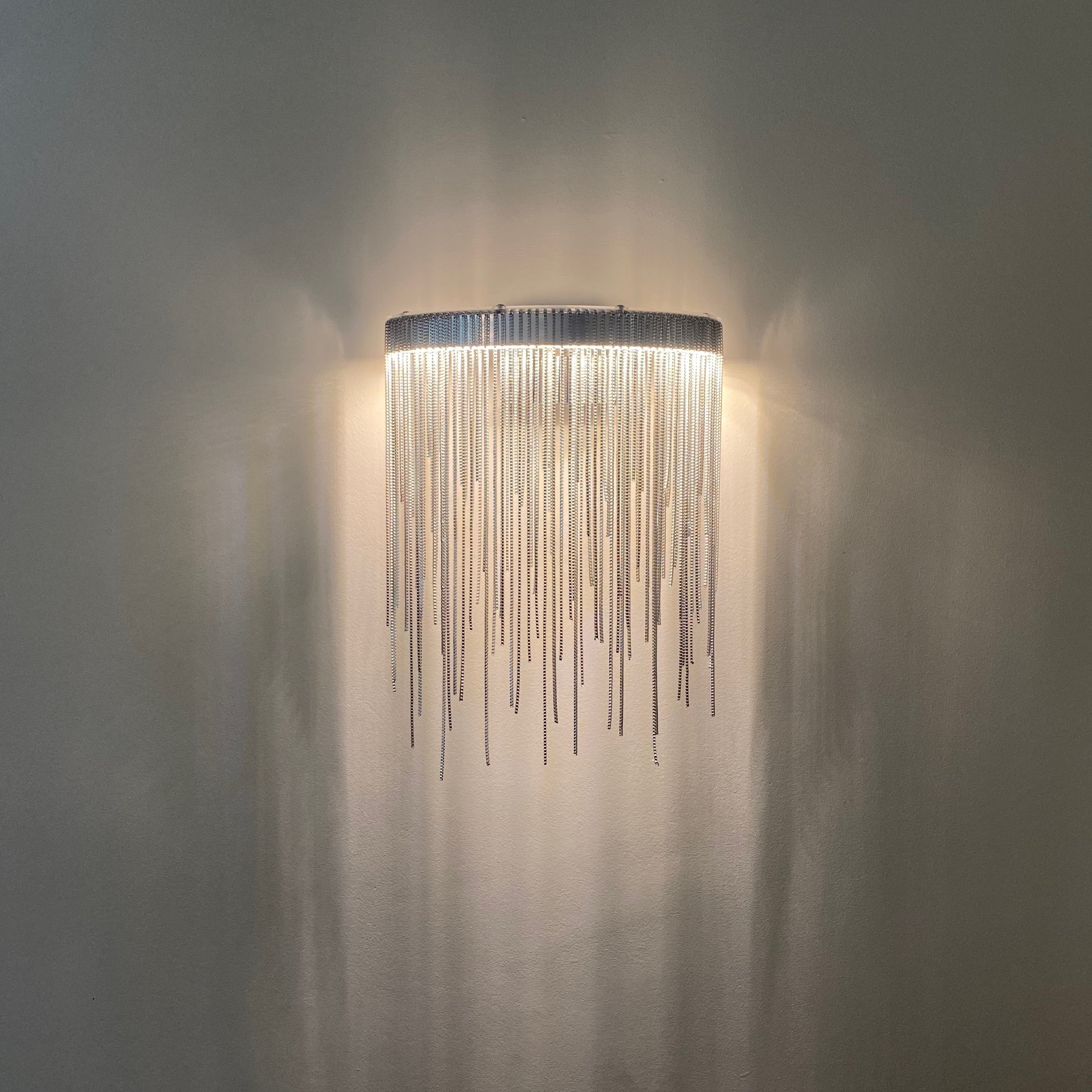 Luxury cascading chain wall sconce with soft glow in UAE home
