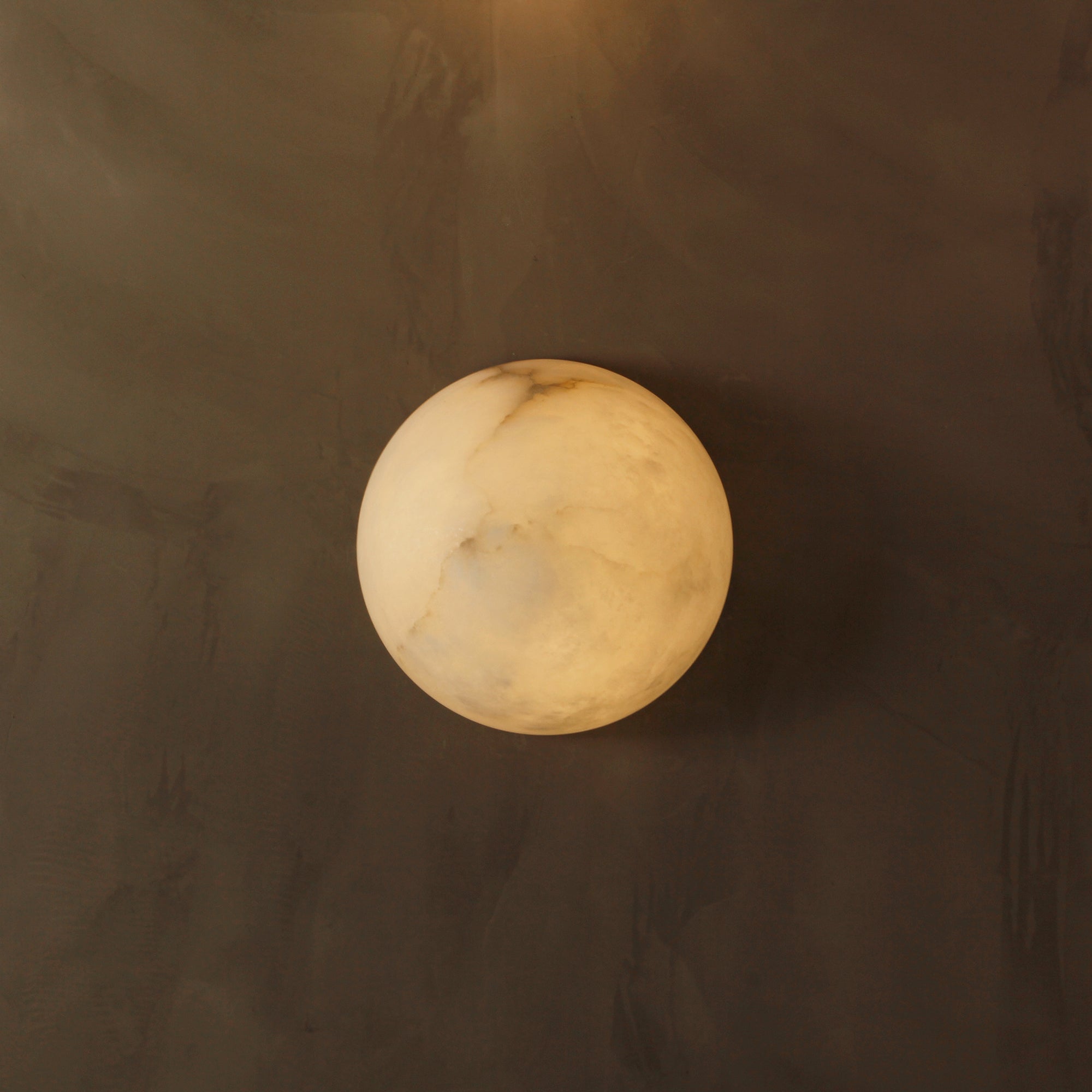 Front view of Arona marble wall light in warm ambient setting
