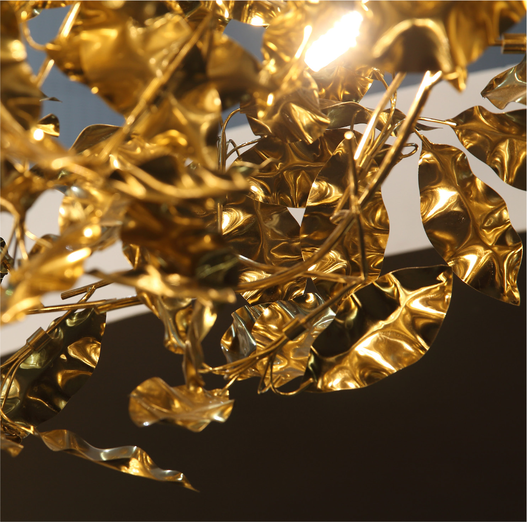 Close-up of sculpted metallic gold leaves on Aureus staircase chandelier
