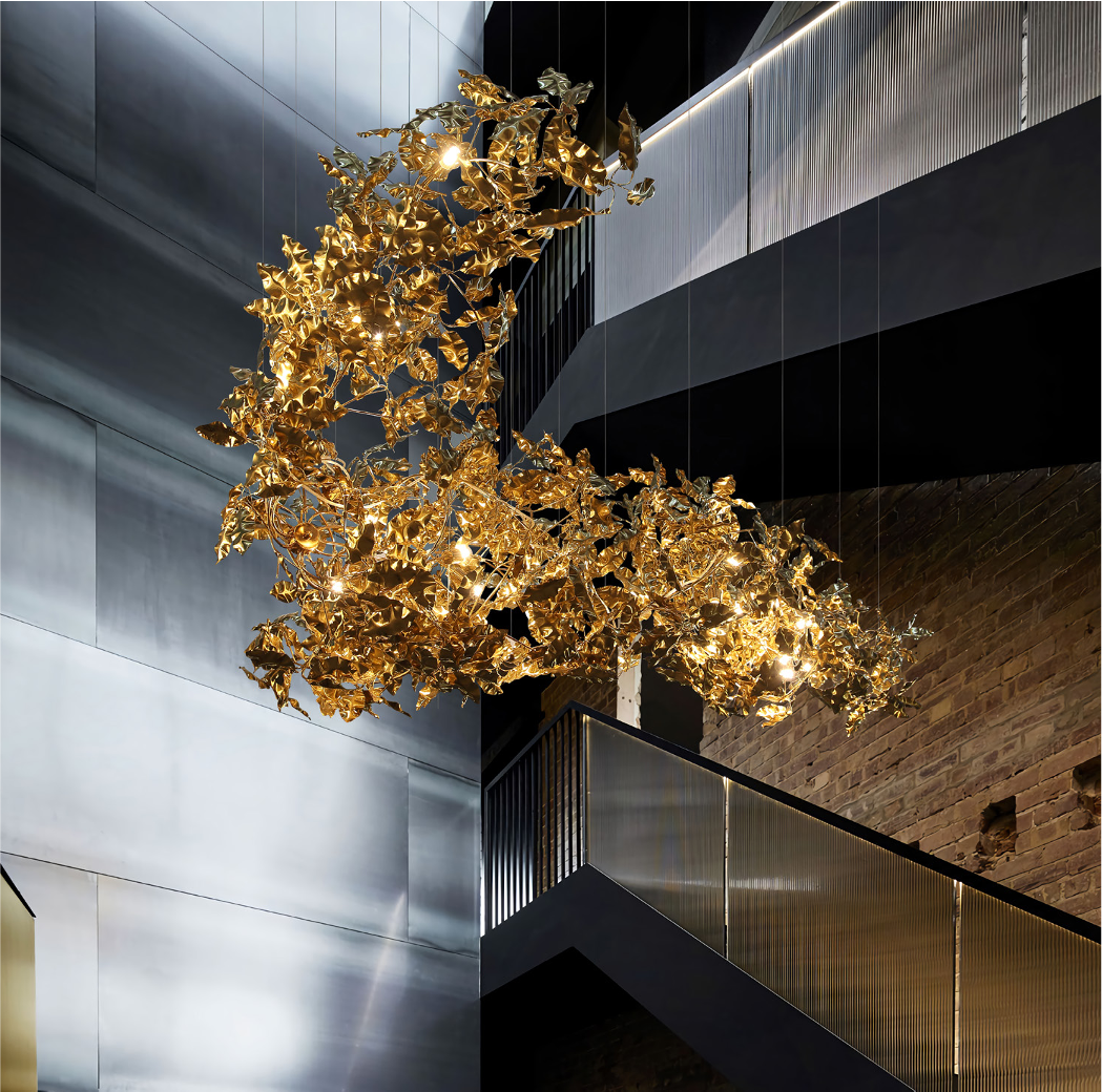 Aureus gold leaf chandelier installed in modern luxury staircase interior