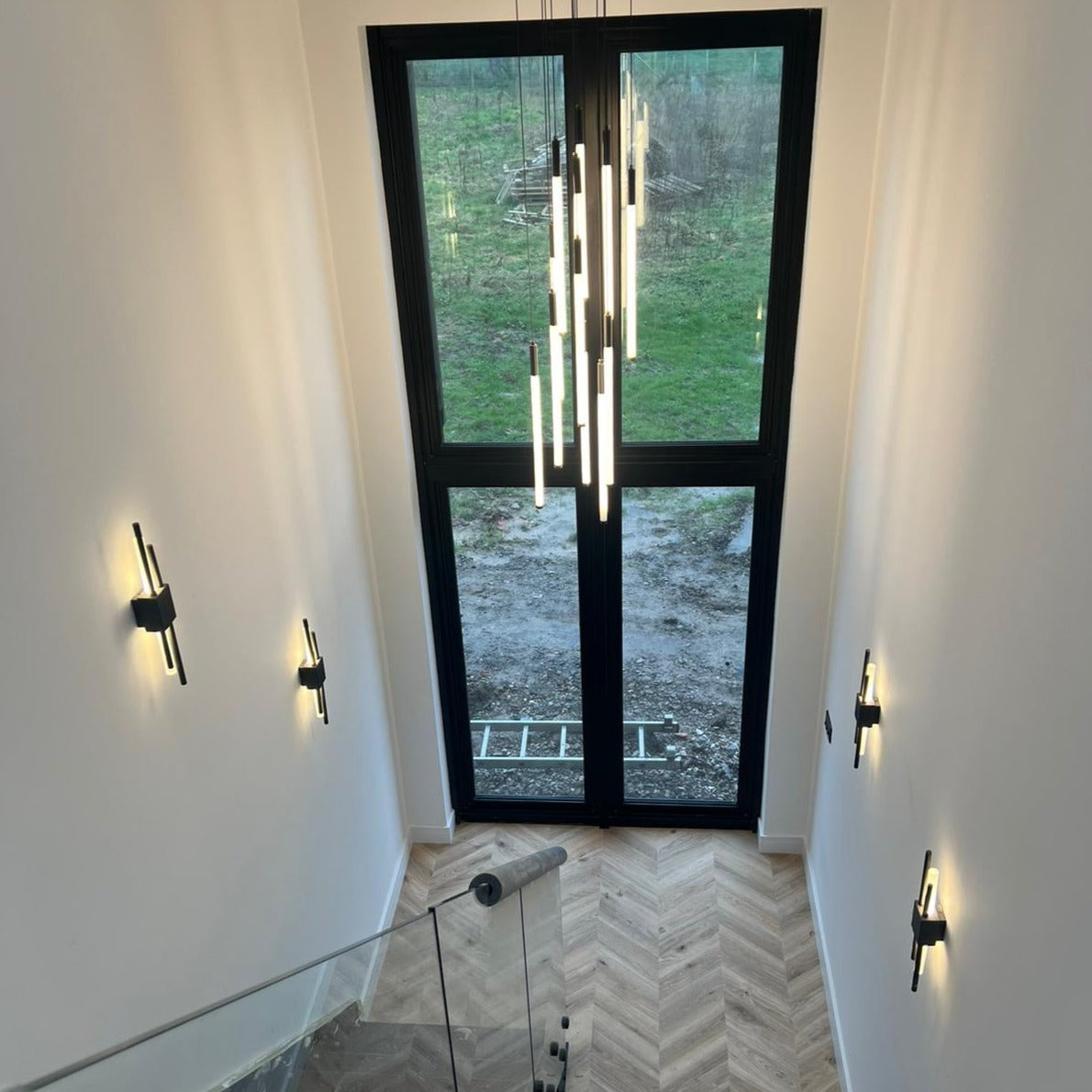 Warm vertical glow of the Avezzano Pendant Staircase Chandelier from a side angle.
