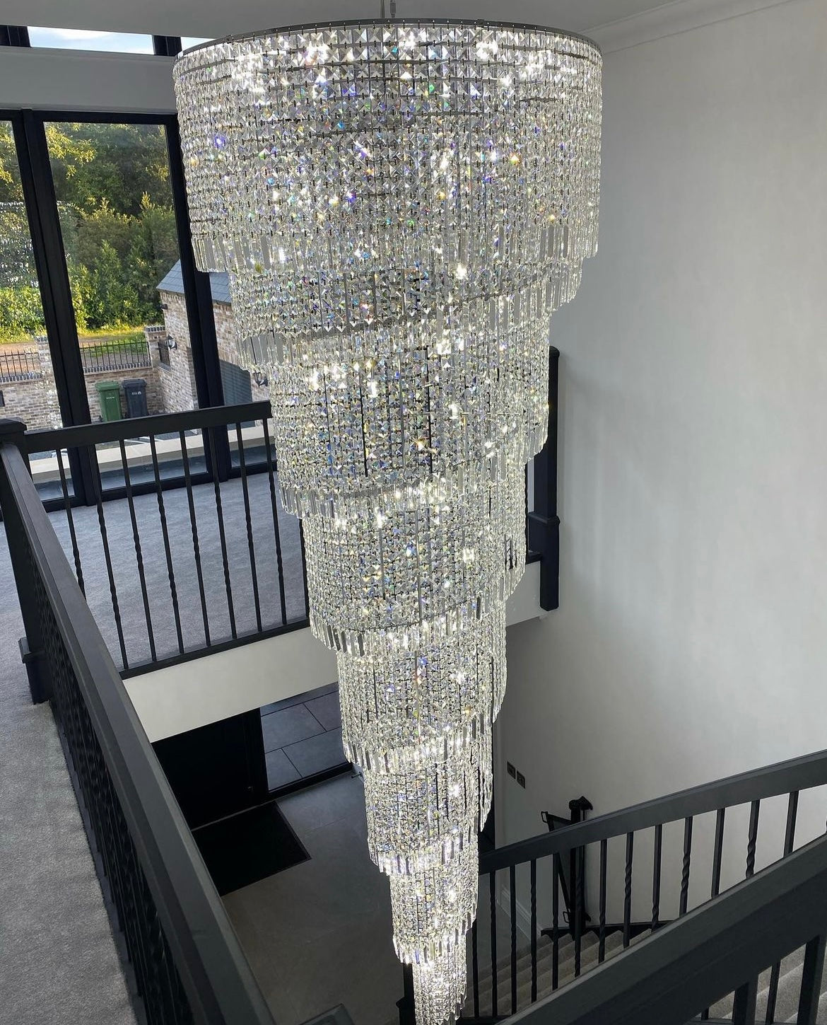 Top-floor perspective of Basiglio spiral chandelier cascading down stairwell