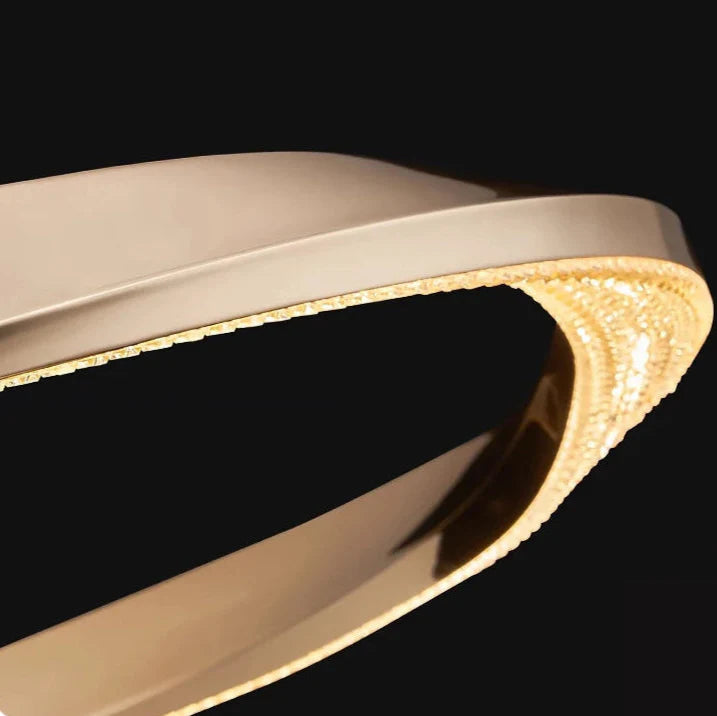 Close-up of polished gold ribbon frame on rectangular chandelier