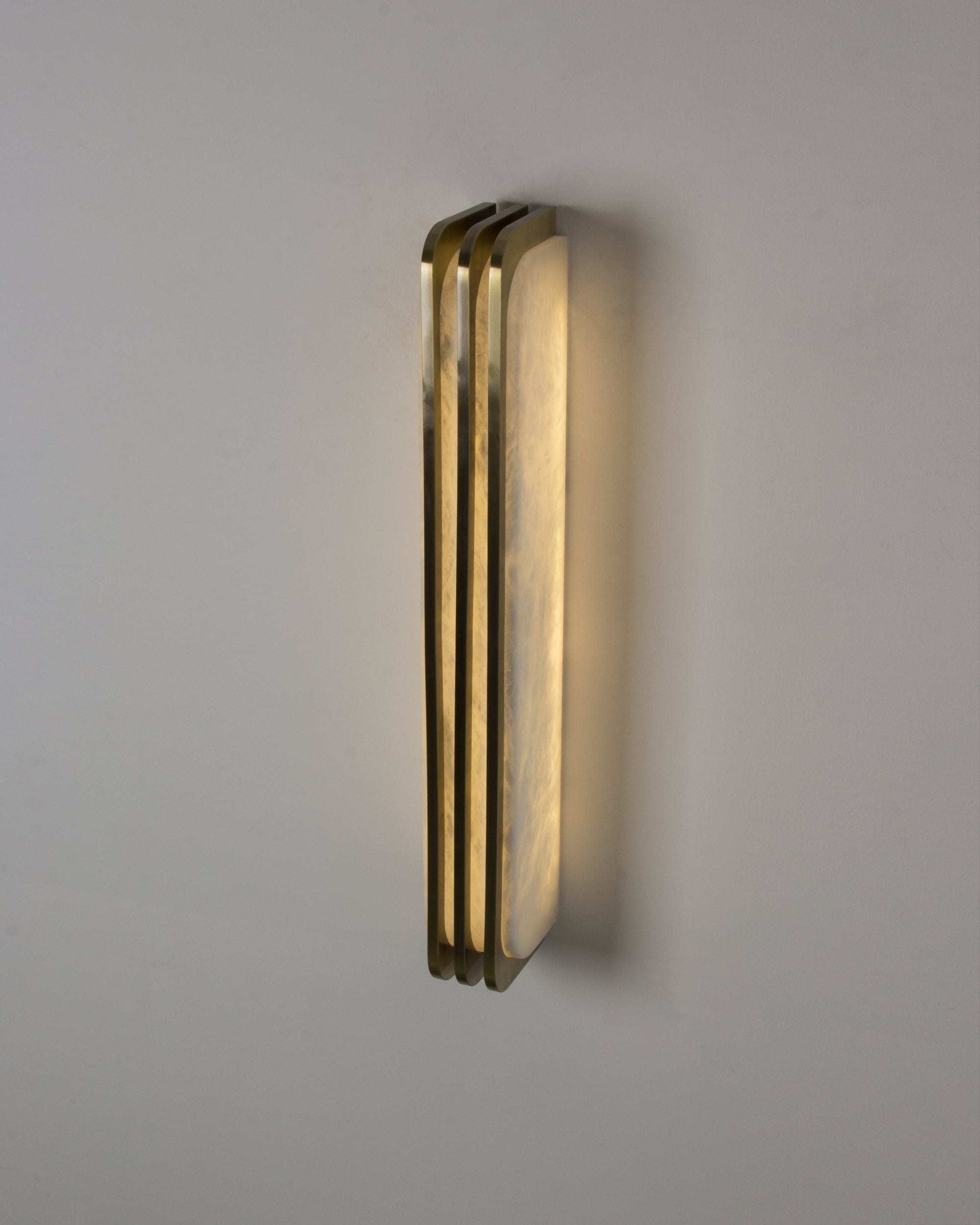 Angled view of Bellagio marble wall light with gold edging