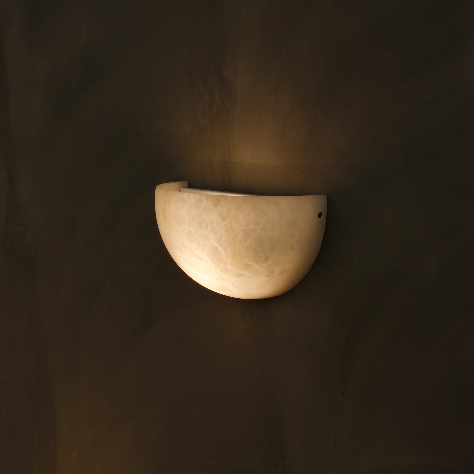 Close-up of Belluno marble wall sconce showing natural stone texture