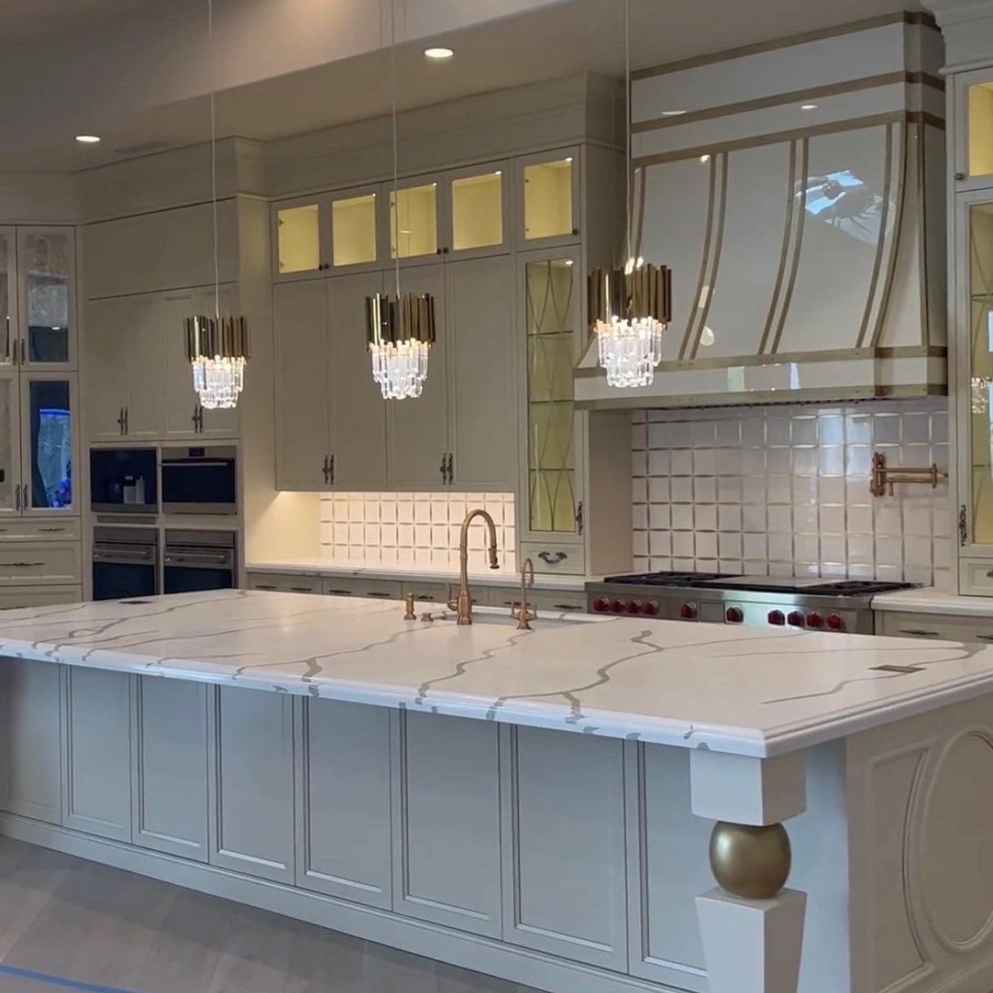 Boeotia gold and crystal pendant above modern kitchen island